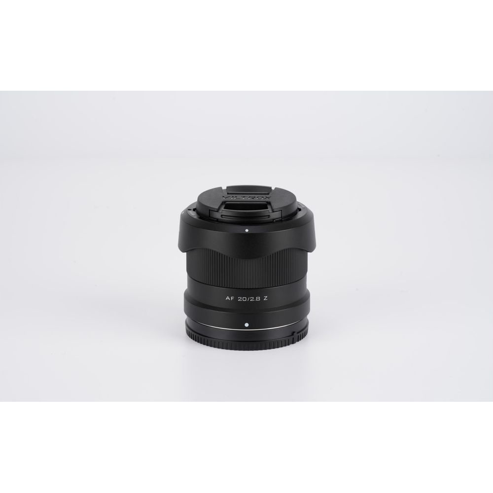 Un obiettivo fotografico nero Viltrox AF 20/2.8 Z posizionato in verticale su sfondo bianco con tappo.