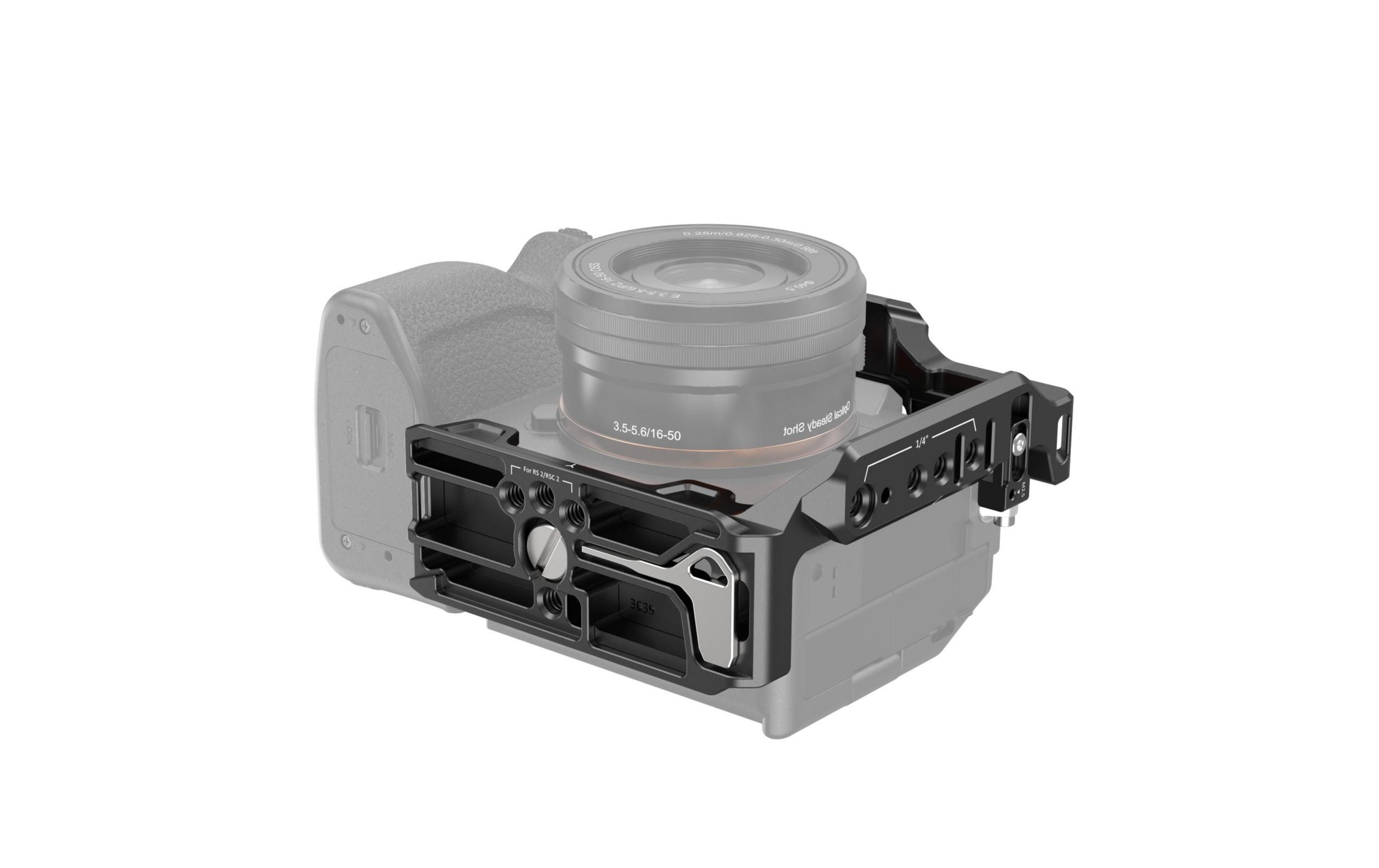 Gabbia per fotocamera in metallo nero montata su una fotocamera mirrorless sfumata di grigio con obiettivo su sfondo bianco.