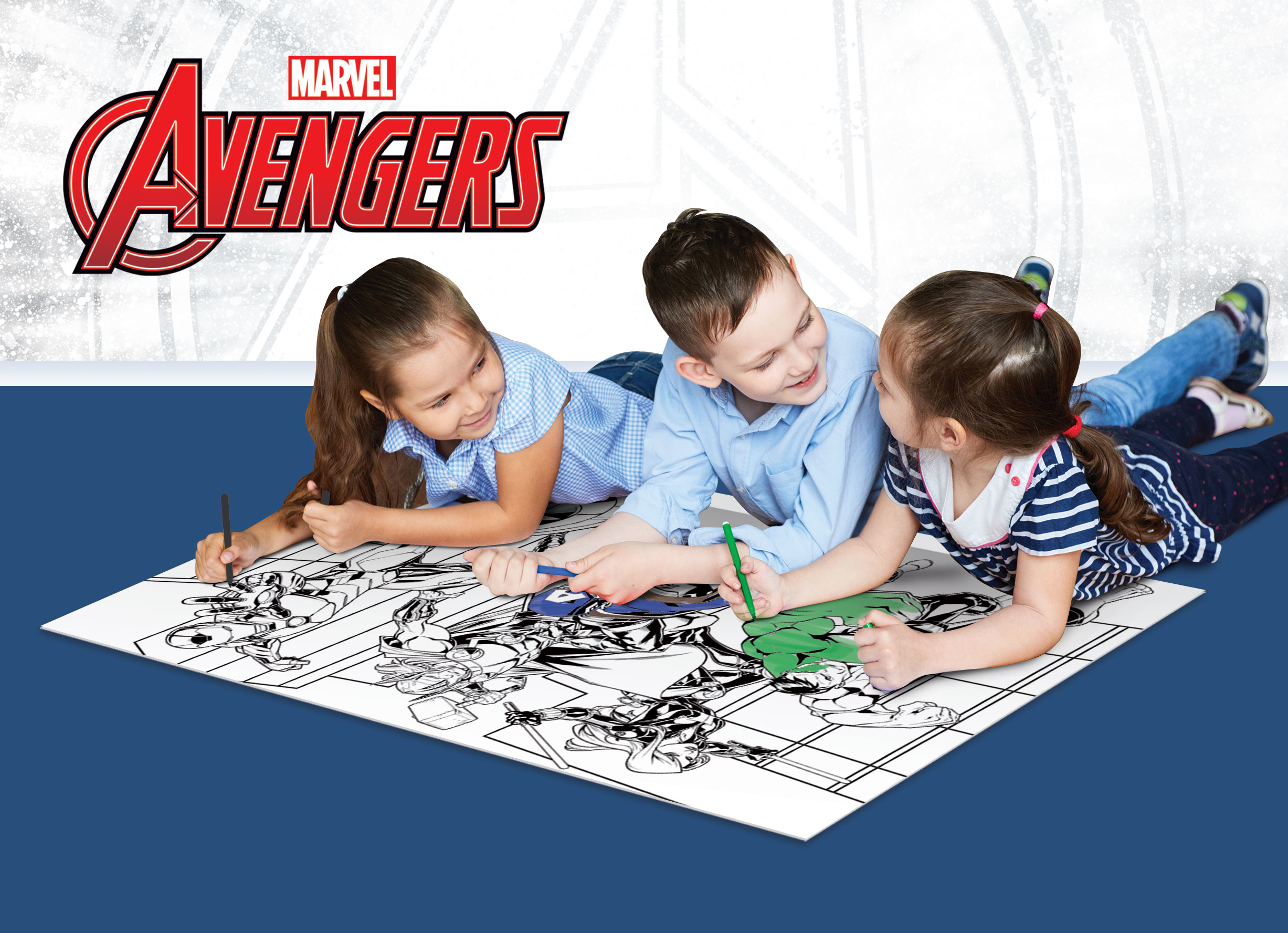 Tres niños están tumbados en el suelo coloreando juntos en un gran libro de Marvel Avengers.