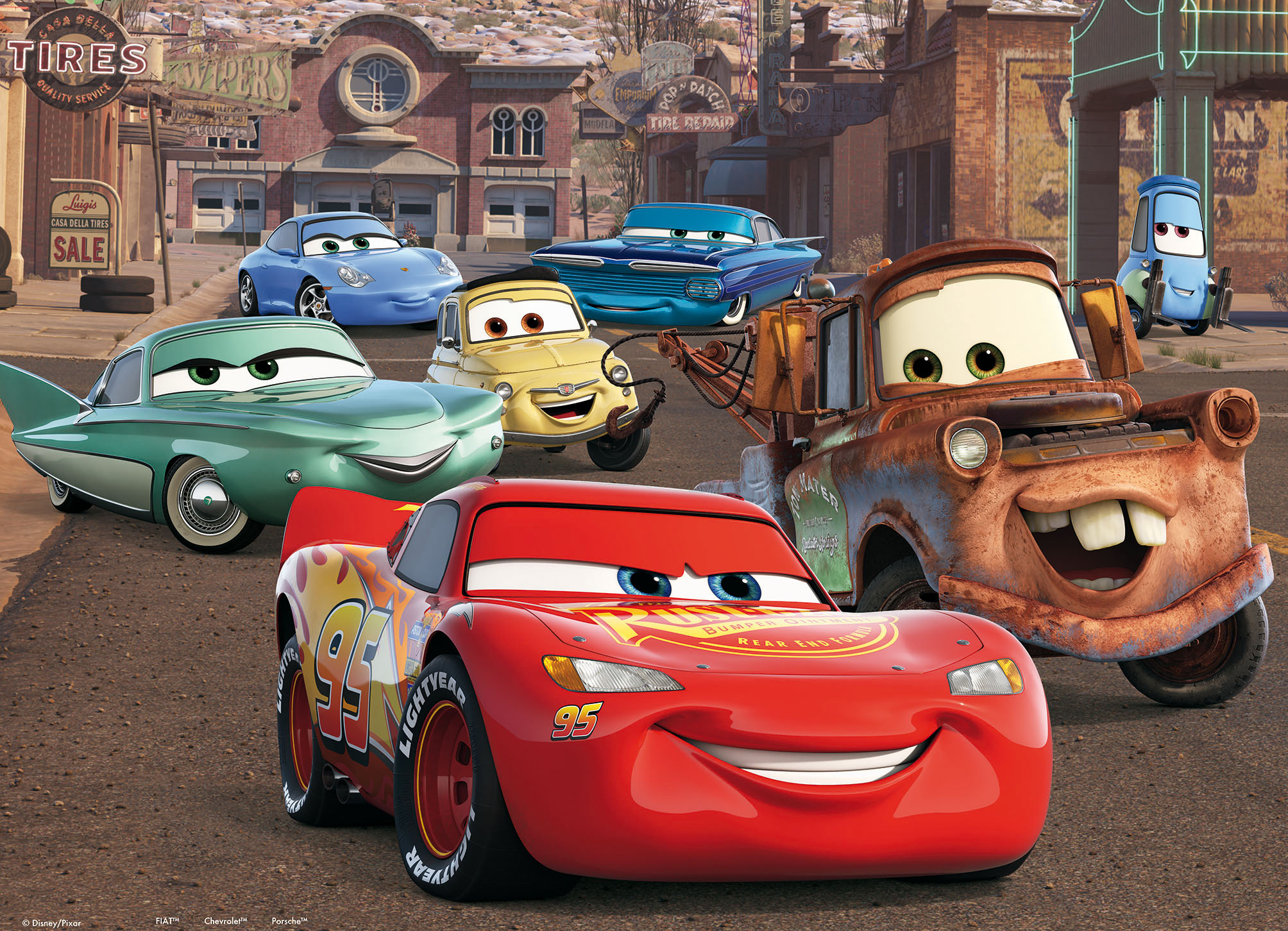Verschiedene anthropomorphe Autos mit Gesichtern aus dem Film Cars stehen auf einer Wüstenstraße.