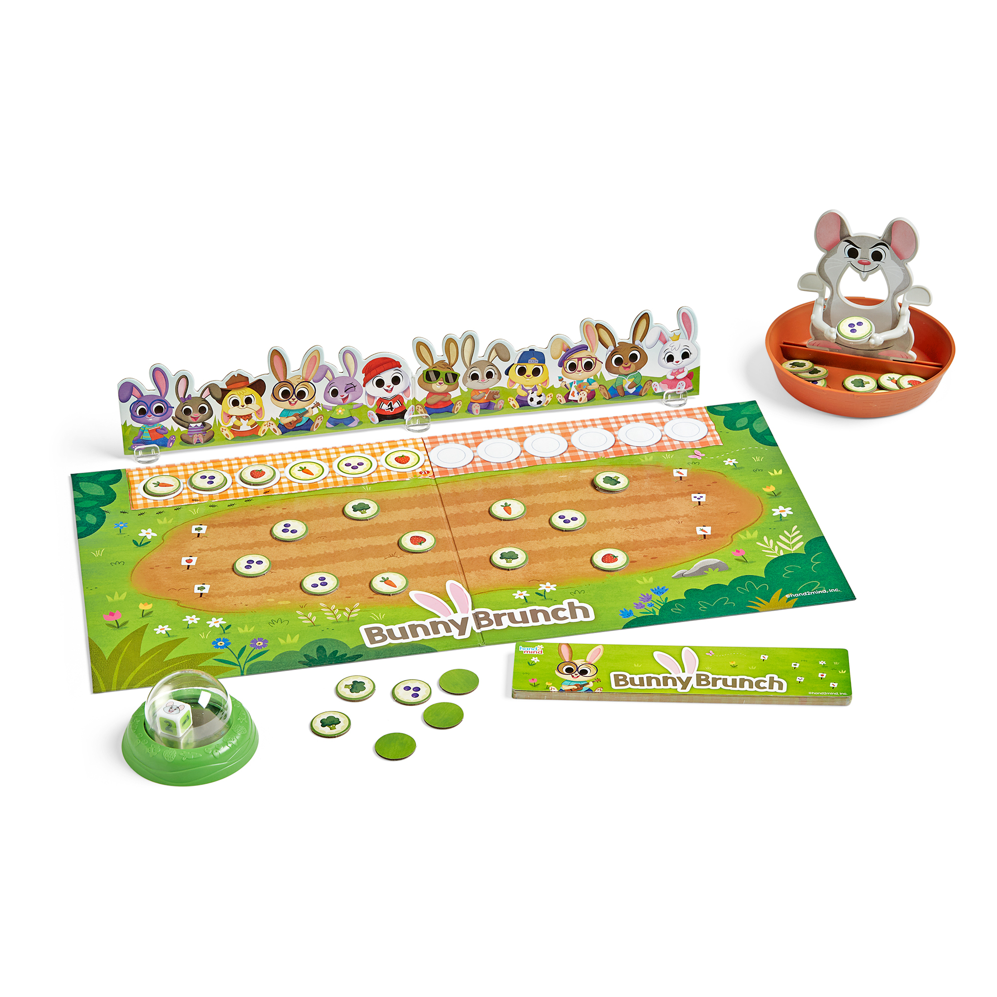 Das Brettspiel Bunny Brunch mit bunten Hasenfiguren, Gartenmatte, Würfel und Spielteilen auf weißem Grund.