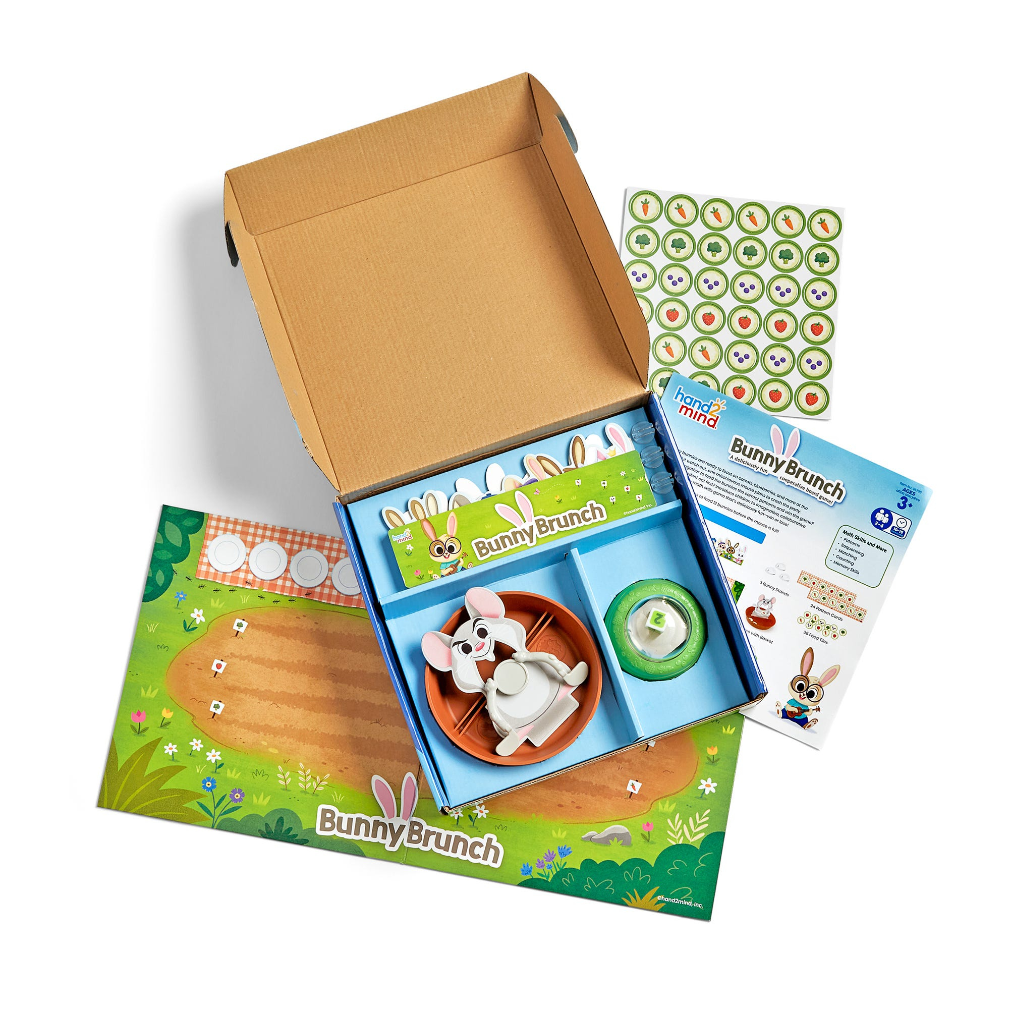 Offene Spieleschachtel Bunny Brunch zeigt Spielfiguren, ein Brett, Aufkleber und Zubehör auf weißem Hintergrund.