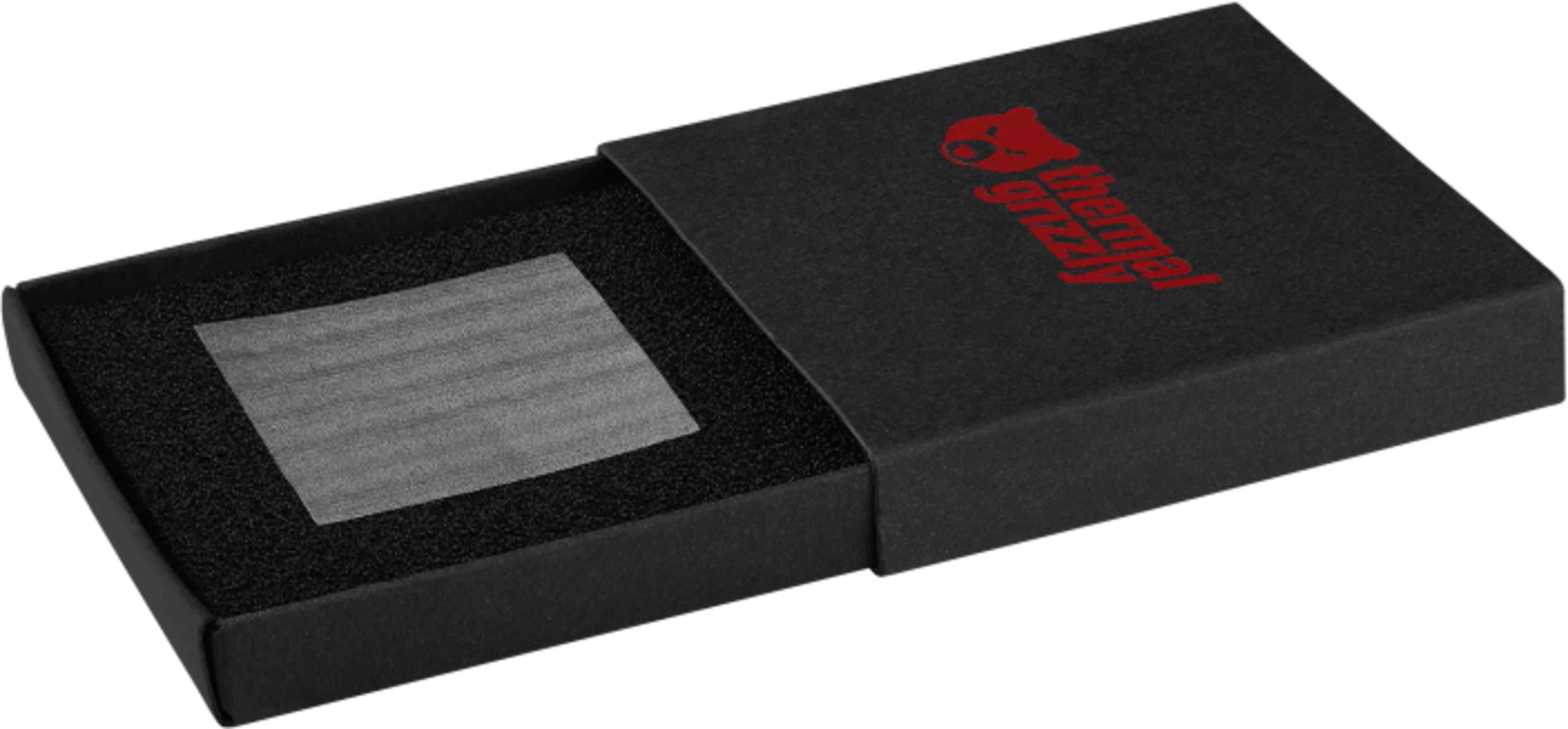 Una caja negra abierta con un logo rojo muestra una almohadilla térmica gris sobre espuma.