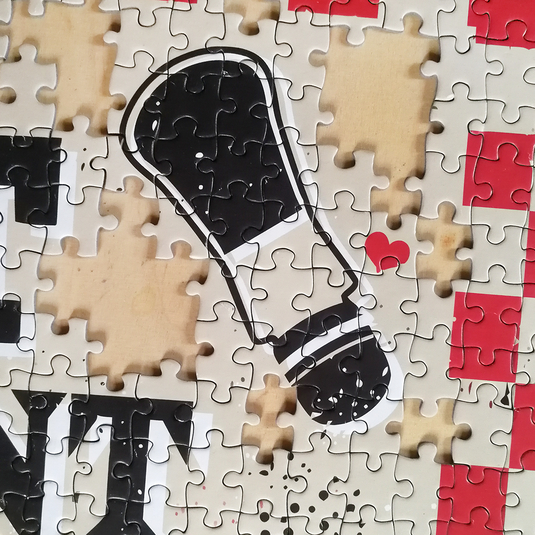 Ein unvollständiges Puzzle mit einem Schuhabdruck und einem kleinen roten Herz.