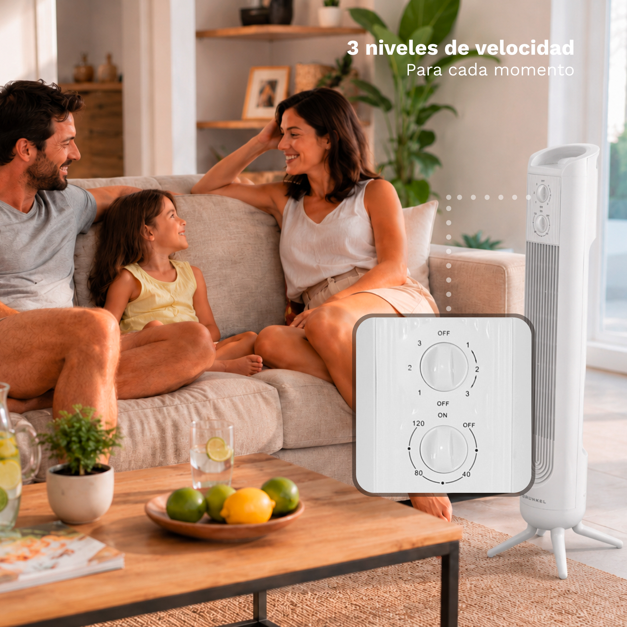 Familia en el sofá en una sala con un ventilador de torre blanco moderno y fruta en la mesa.
