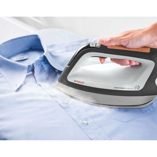 Una mano plancha una camisa azul clara usando una plancha de vapor moderna.