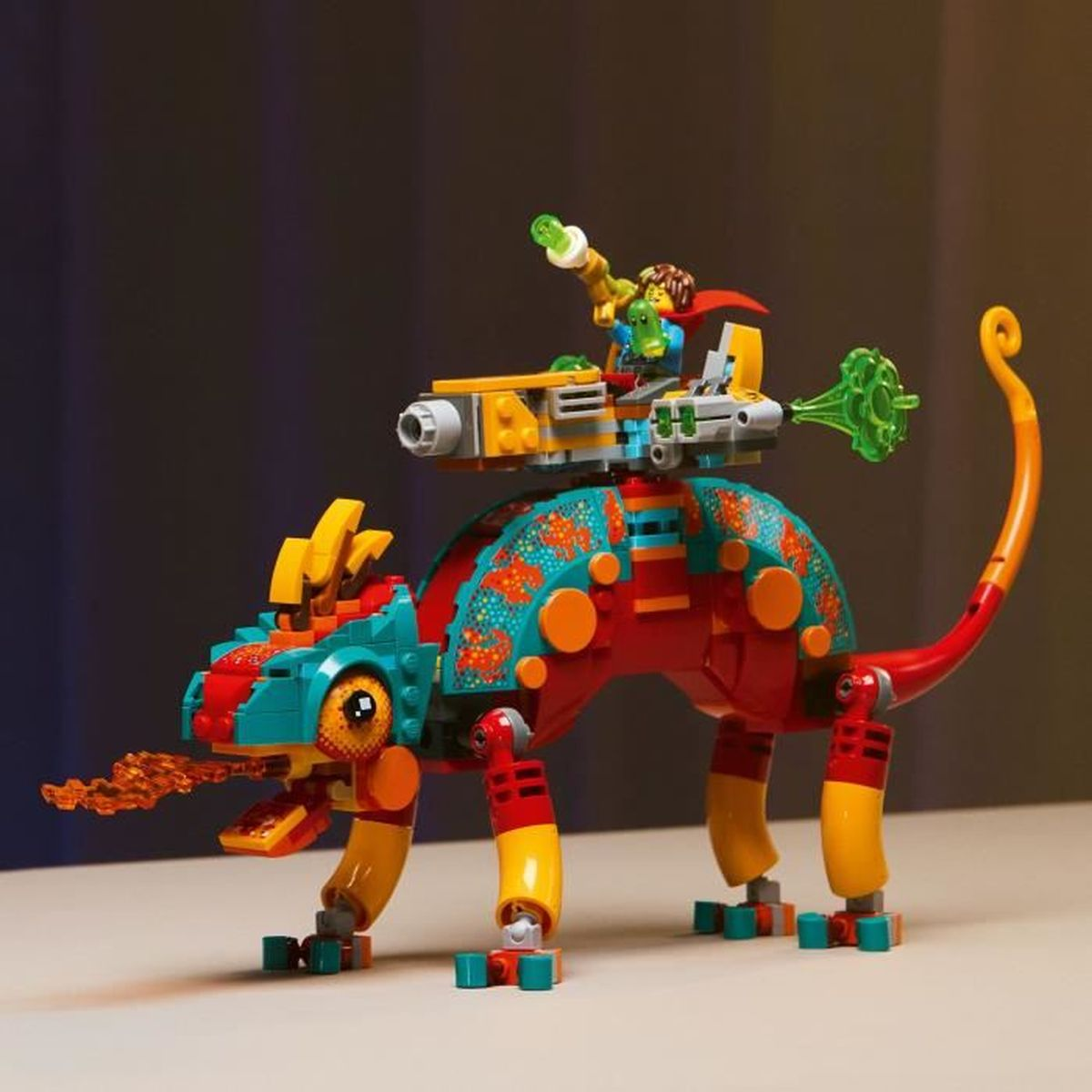 Un colorido camaleón de Lego con una minifigura montada en su lomo, sobre una superficie clara con fondo degradado.