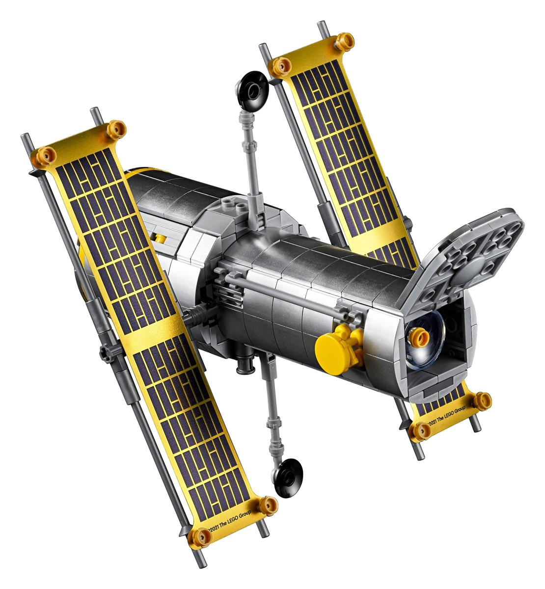 Un modèle Lego détaillé du télescope spatial Hubble avec de grands panneaux solaires déployés sur fond noir.