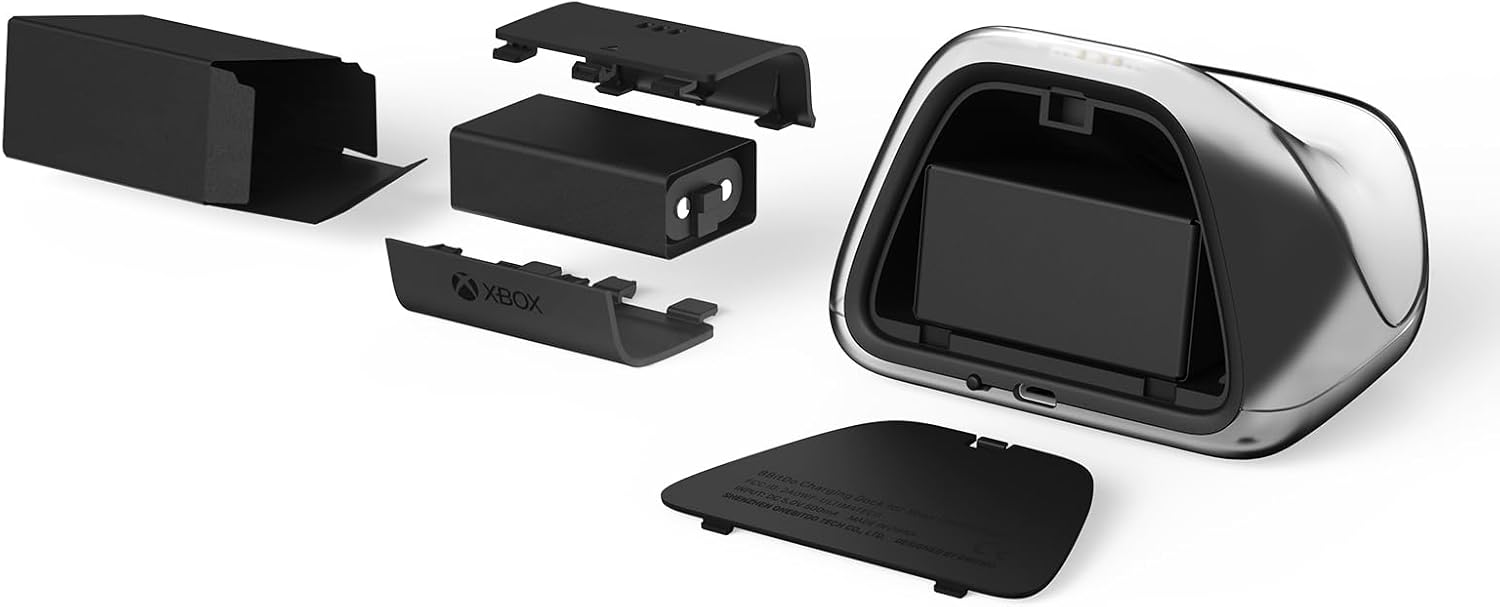 Czarna stacja ładująca Xbox z rozebranymi akumulatorami i pokrywami na białym tle.