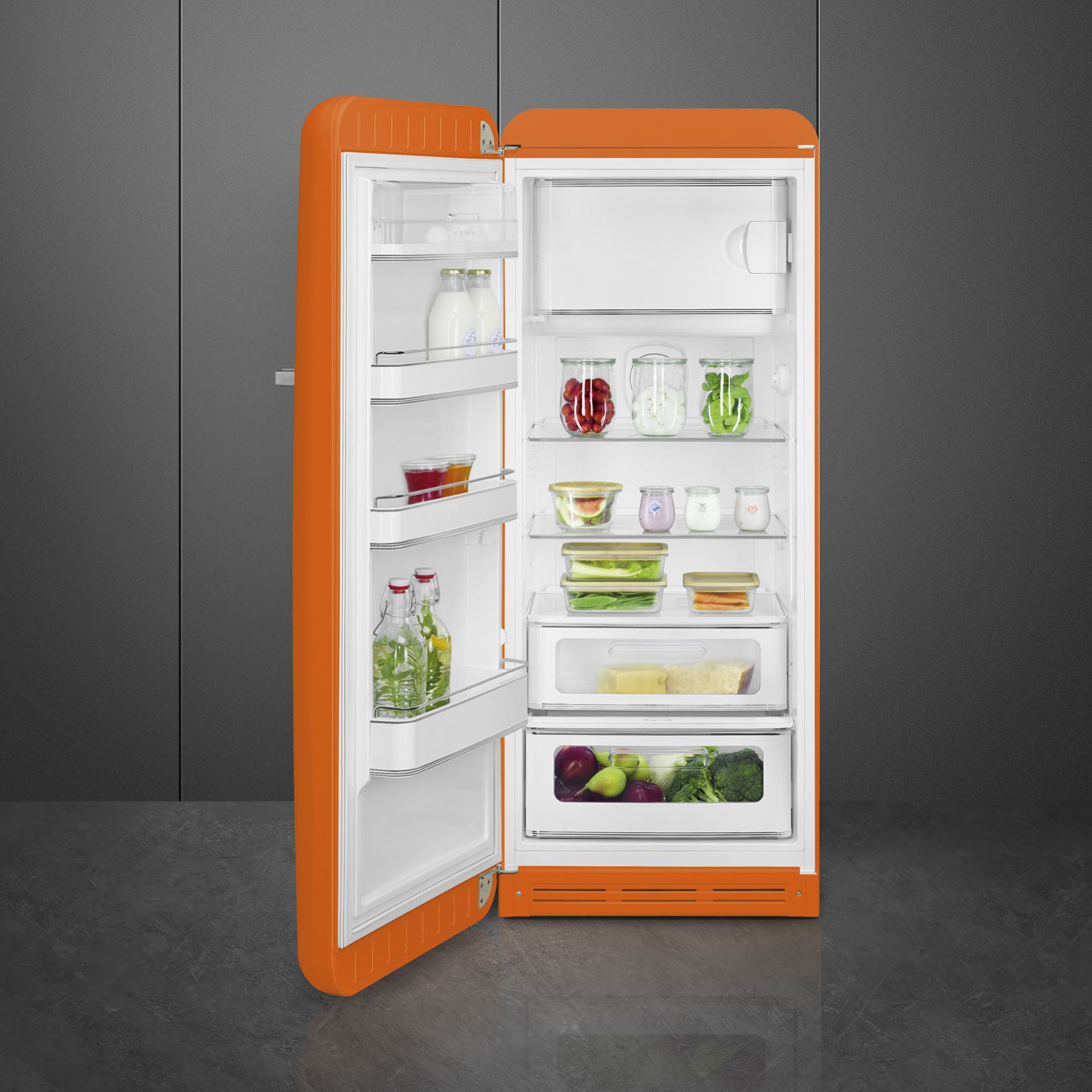 Ein offener, leuchtend orangefarbener Kühlschrank, gefüllt mit gut sortierten Lebensmitteln und Getränken.
