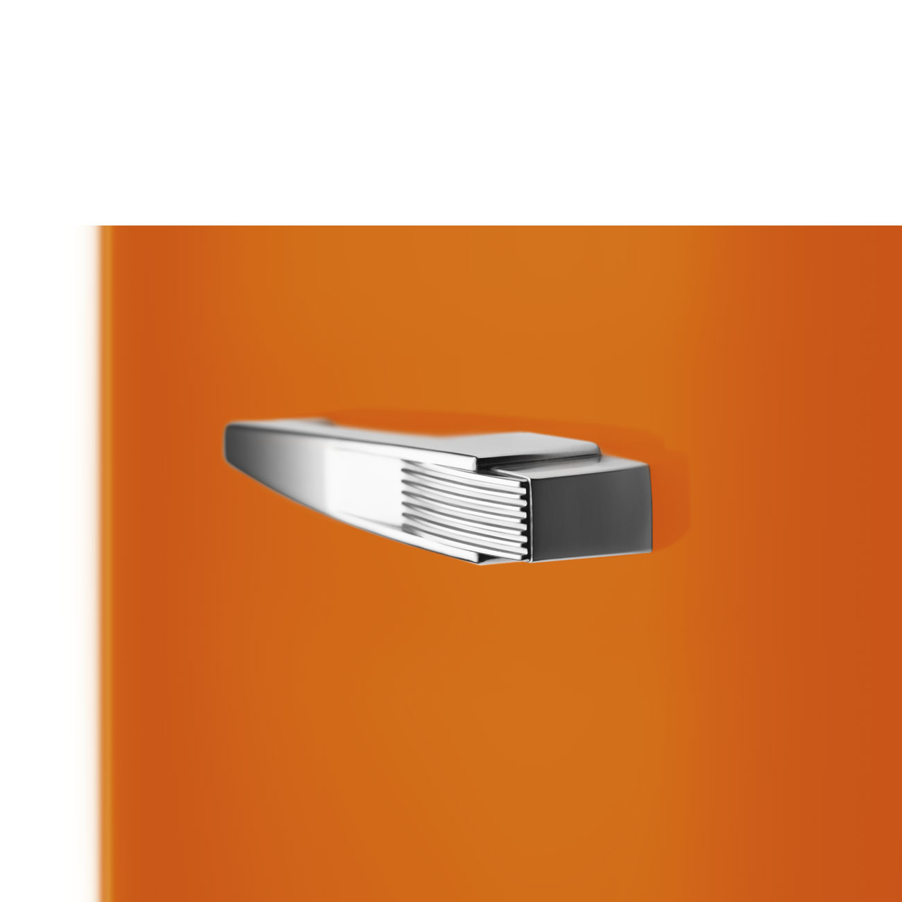 Ein glänzender, silberner Metallgriff an einer glatten orangefarbenen Oberfläche.