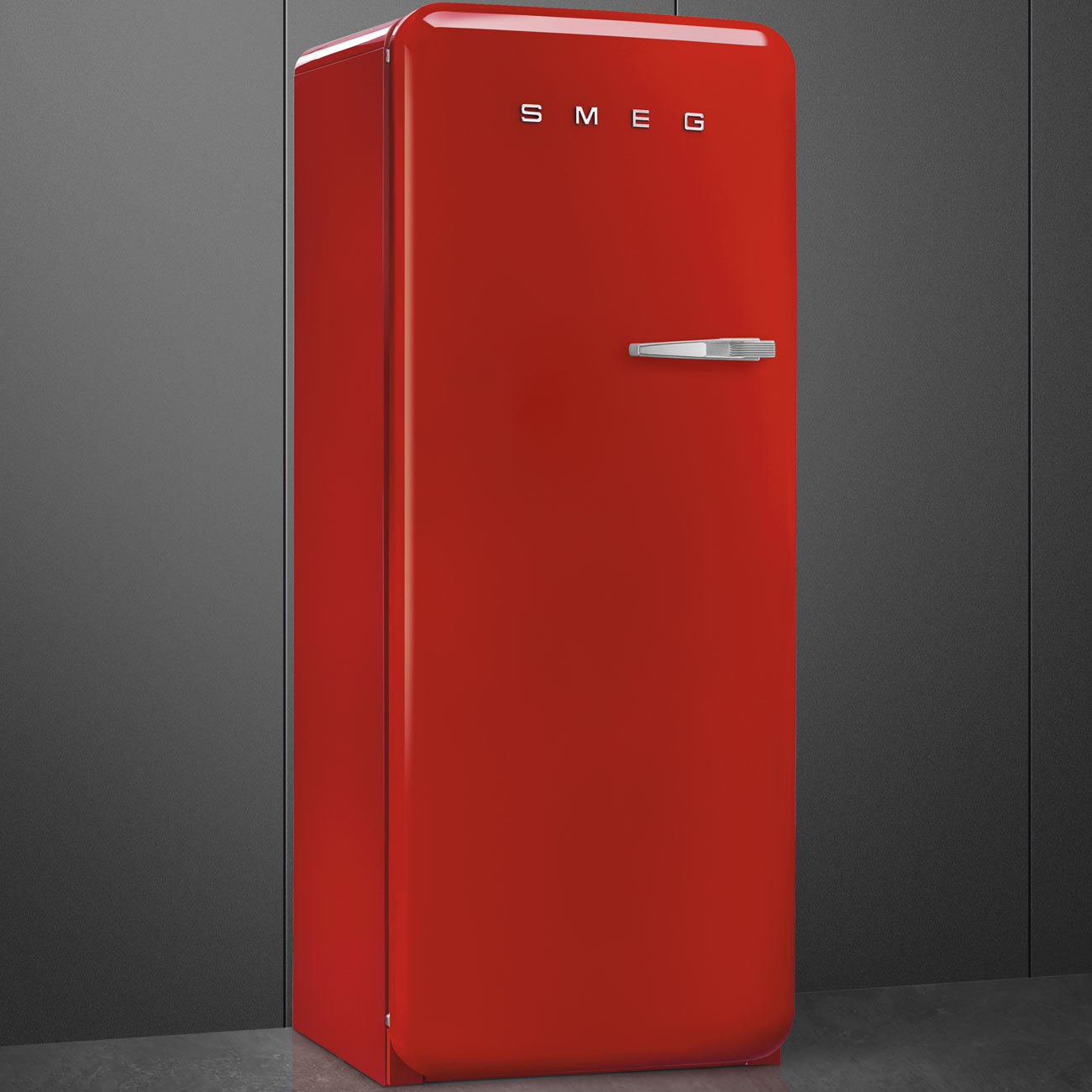 Ein glänzender roter Smeg Kühlschrank mit Chromgriff steht vor einer grauen Wand.