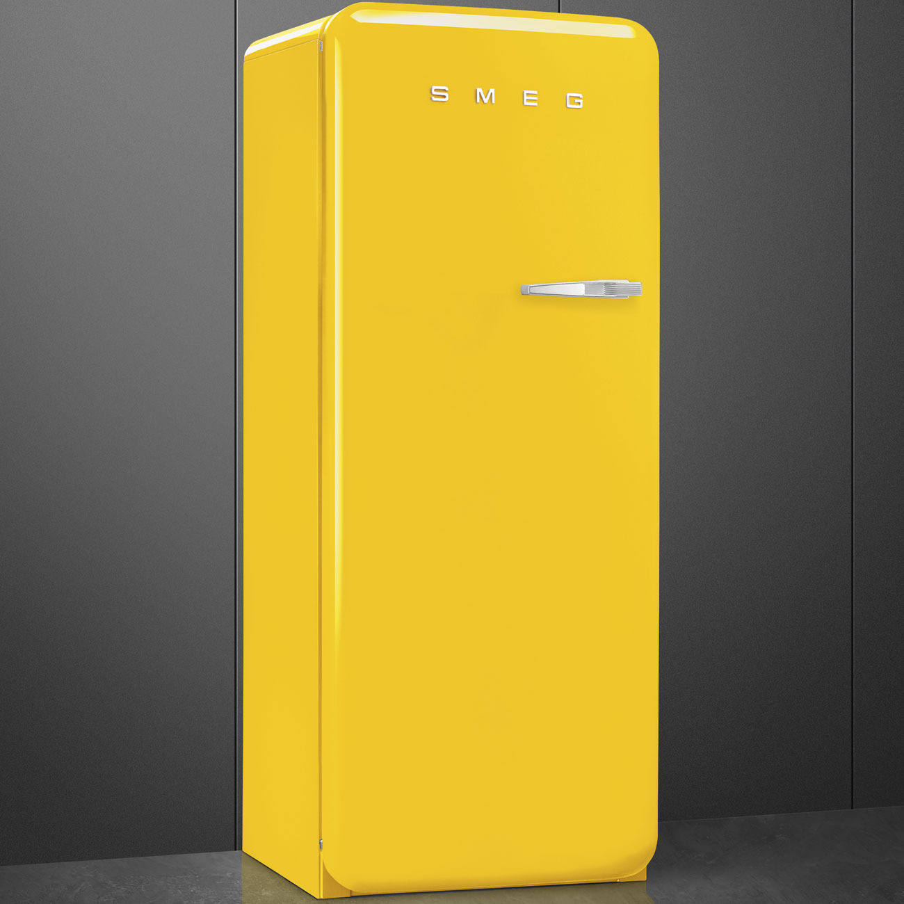 Un refrigerador SMEG amarillo brillante con tirador plateado contra una pared gris oscura.