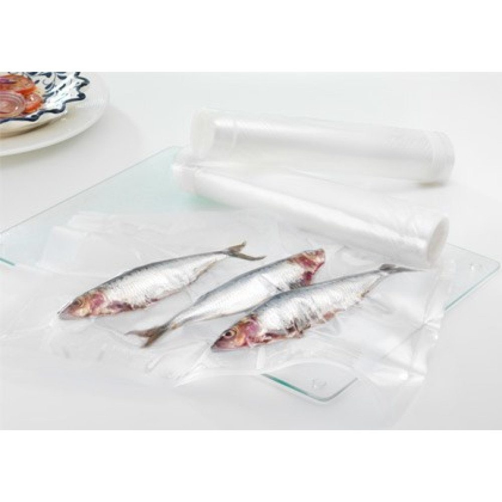 Tres peces pequeños están envasados al vacío en plástico sobre una tabla de vidrio, con rollos al fondo.