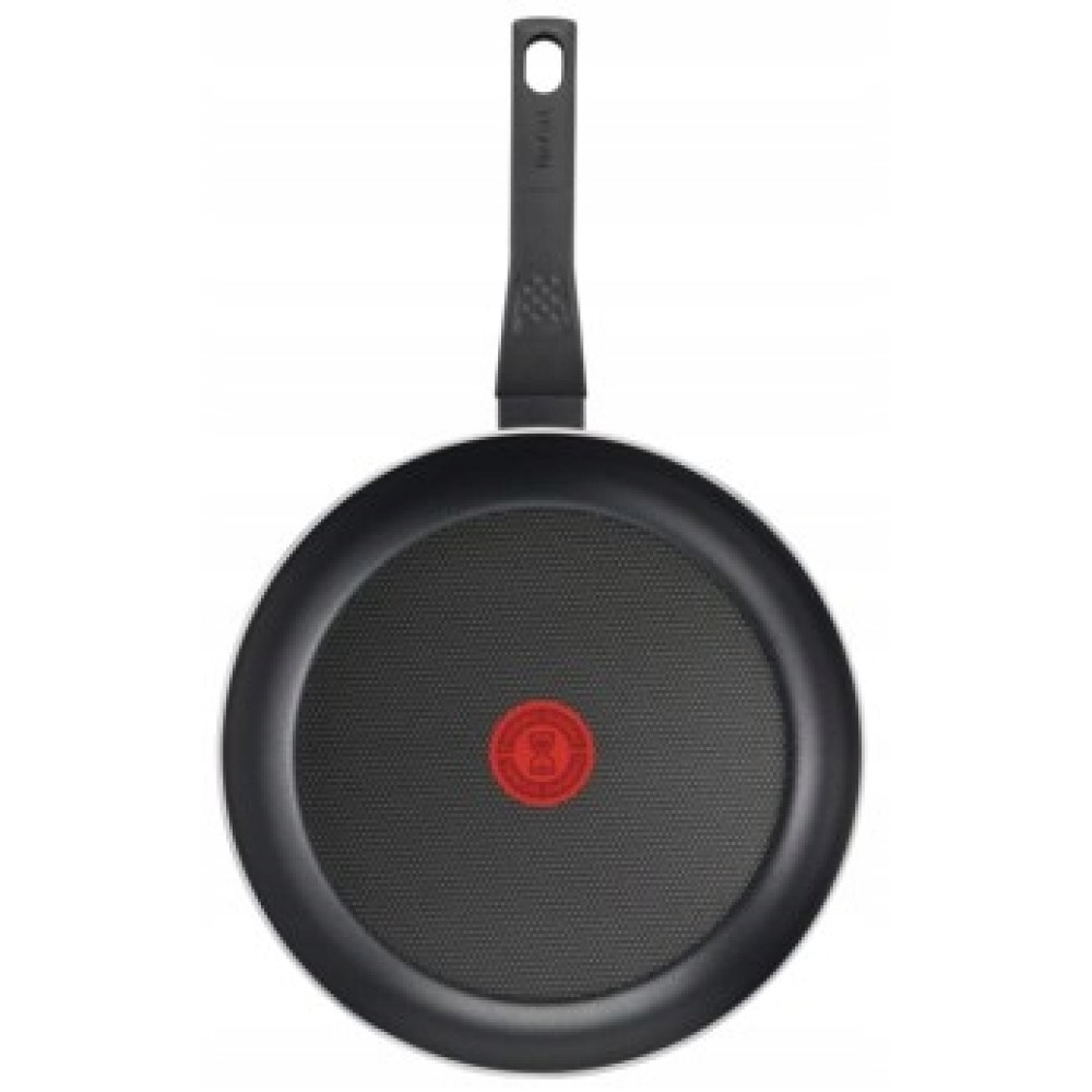Widok od spodu czarnej patelni Tefal z czerwonym czujnikiem ciepła i długą rączką na białym tle.