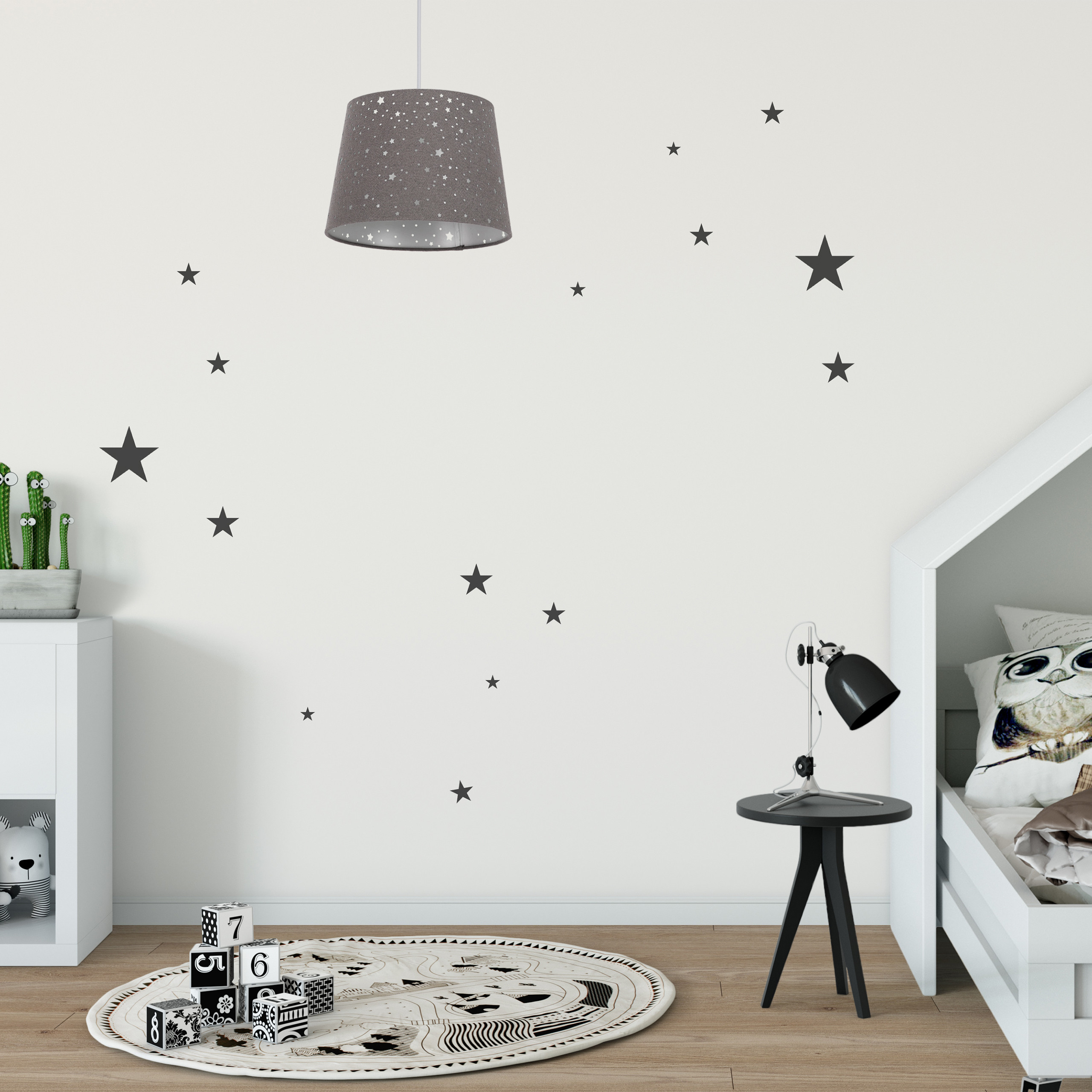 Ein Kinderzimmer mit sternengemusterter Lampe, Wandaufklebern, rundem Teppich, Nummernwürfeln und Hausbett.