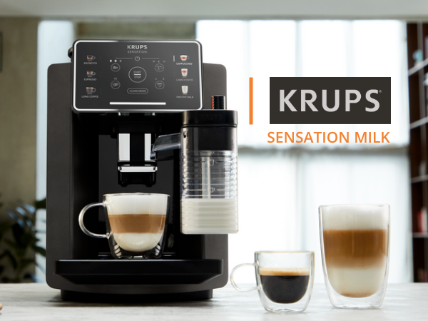 Cafetera negra Krups Sensation Milk con depósito de leche, tazas de cristal llenas y logotipo KRUPS.