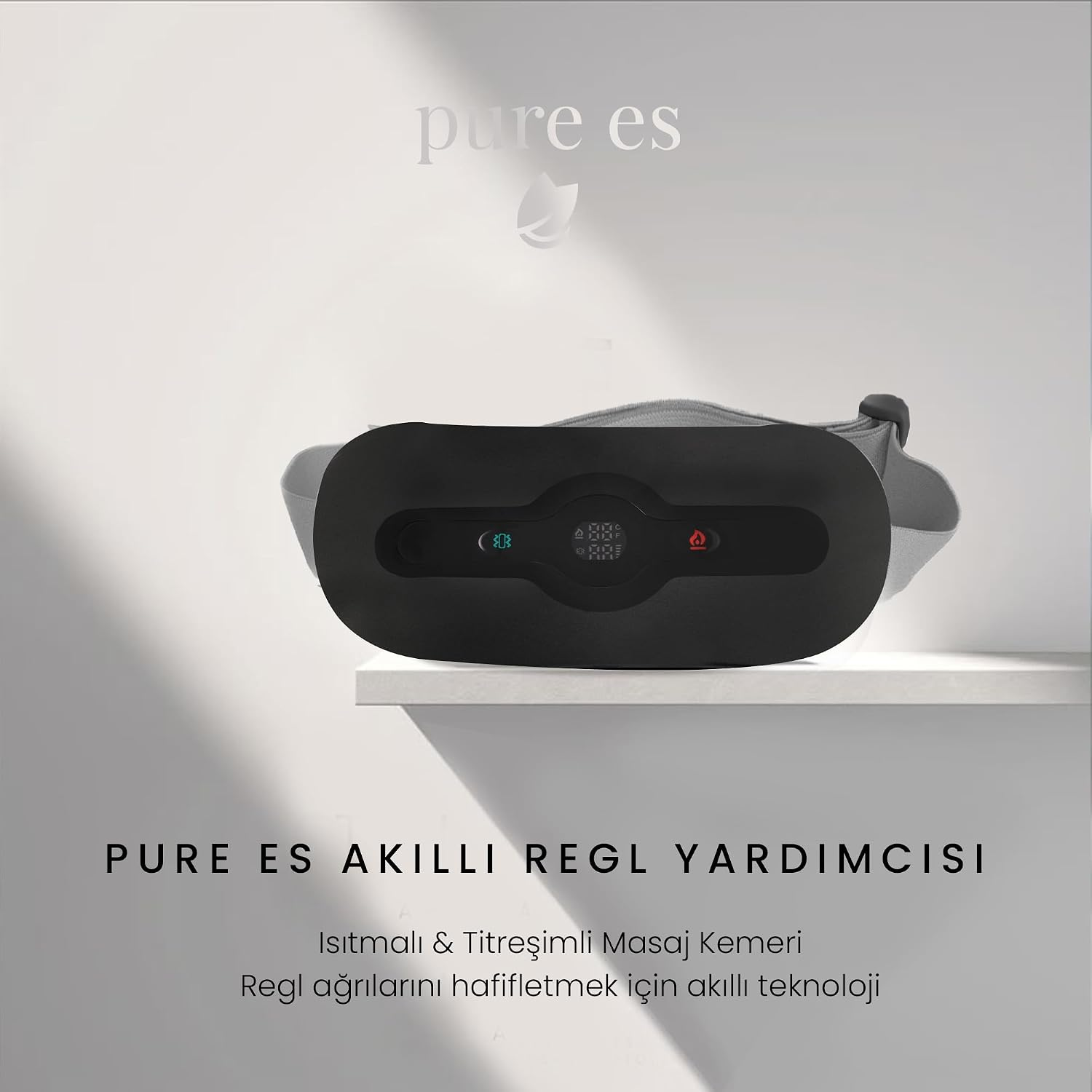 Beyaz bir rafta dijital ekranlı siyah akıllı regl ağrısı giderici masaj kemeri.