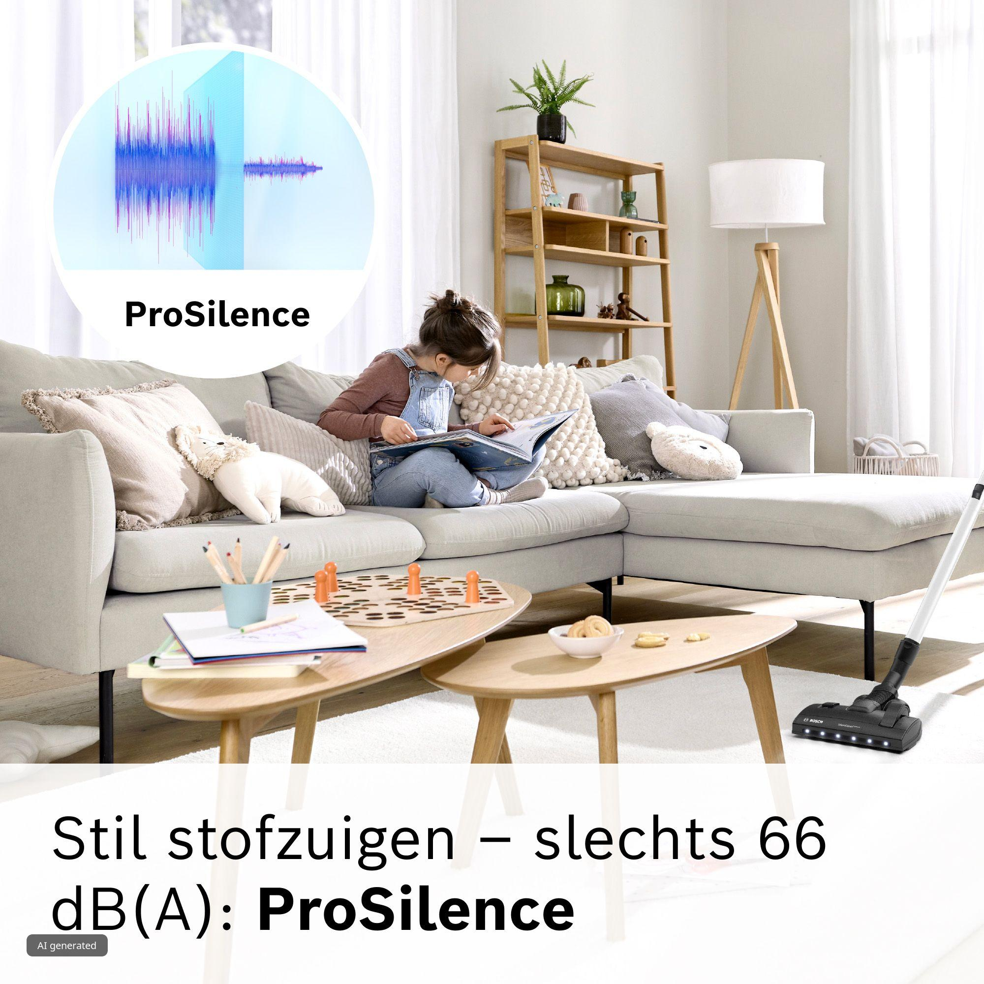 Een kind leest een boek op een grijze bank terwijl een stofzuiger stil reinigt in een rustige woonkamer.