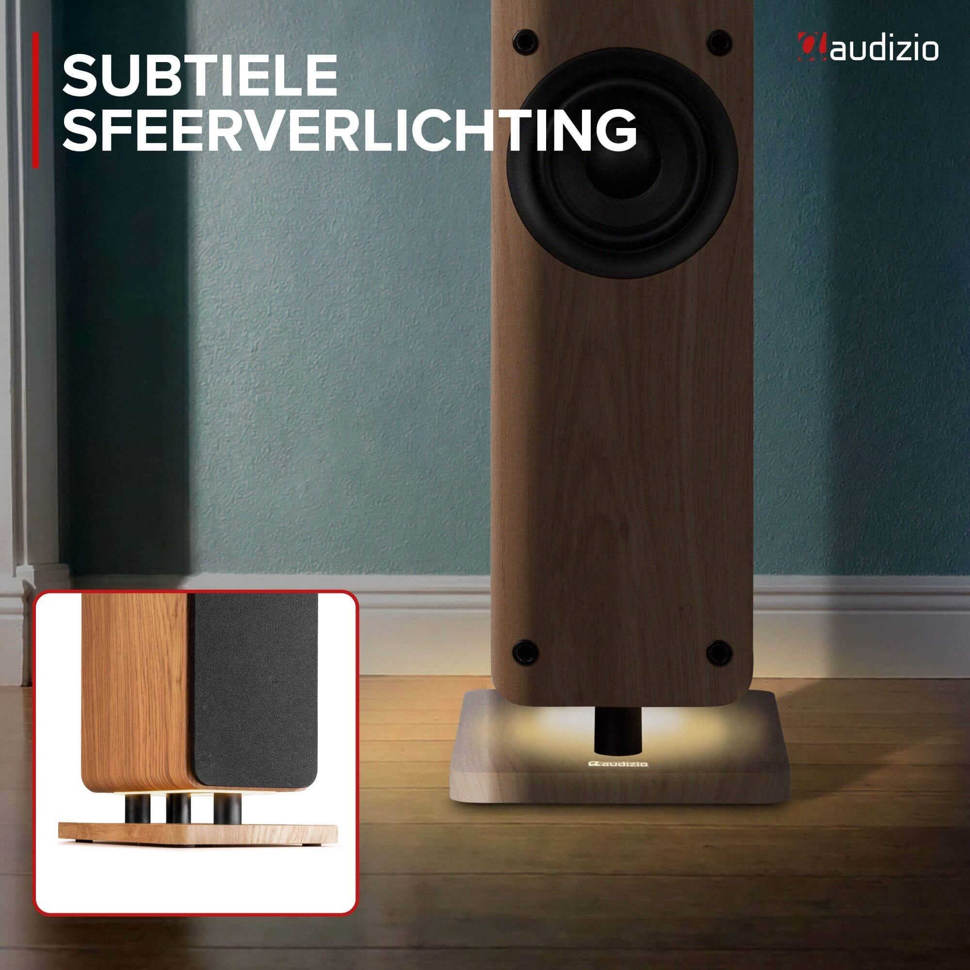 Altavoz de suelo con acabado de madera y sutil iluminación inferior en una habitación.