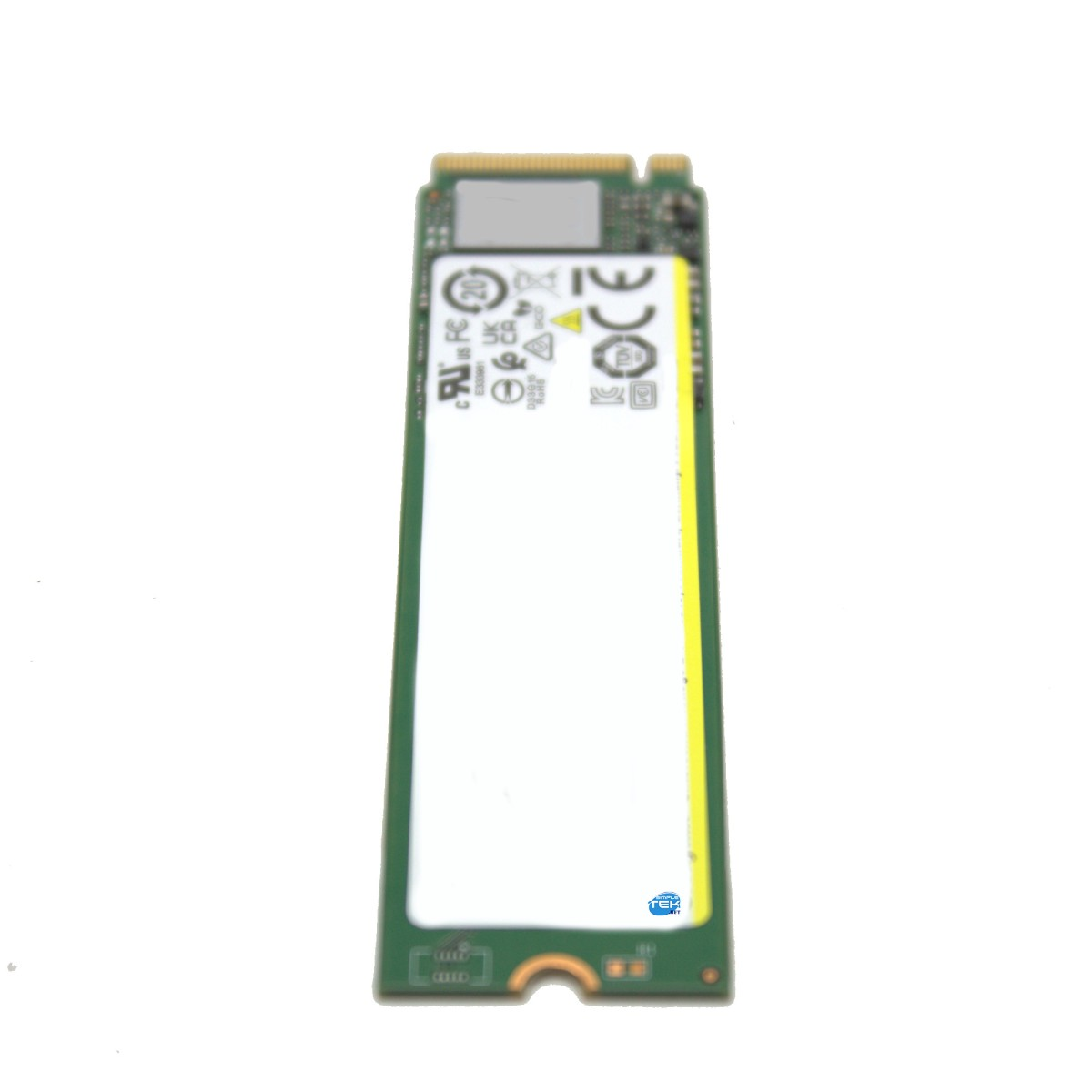 Una tarjeta de memoria M.2 NVMe SSD verde con una etiqueta blanca y símbolos impresos sobre fondo blanco.