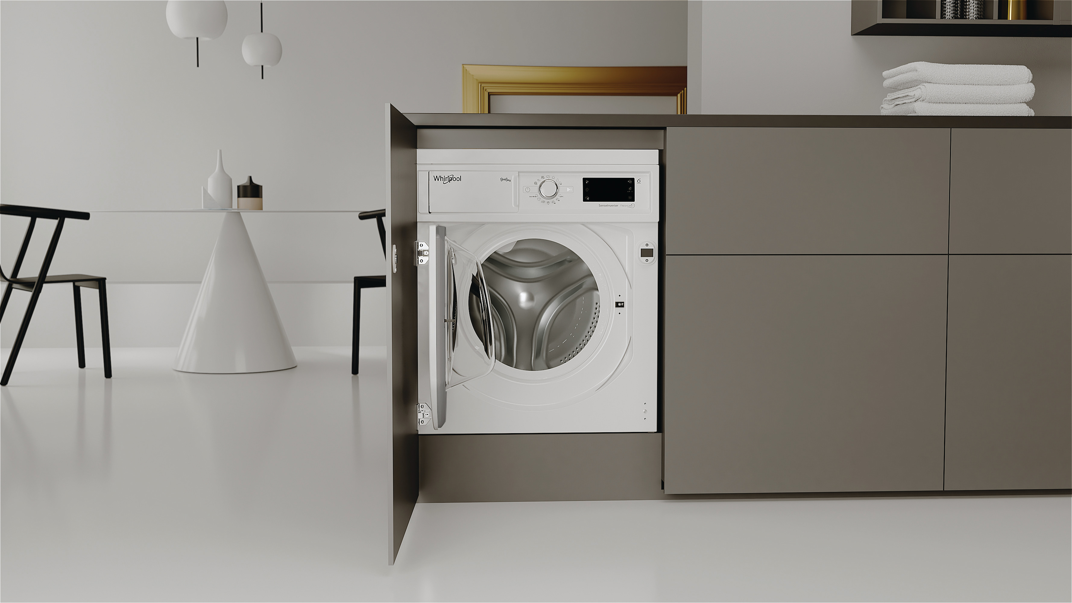 Una lavatrice bianca è installata dietro l'anta di un mobile grigio in una cucina moderna.