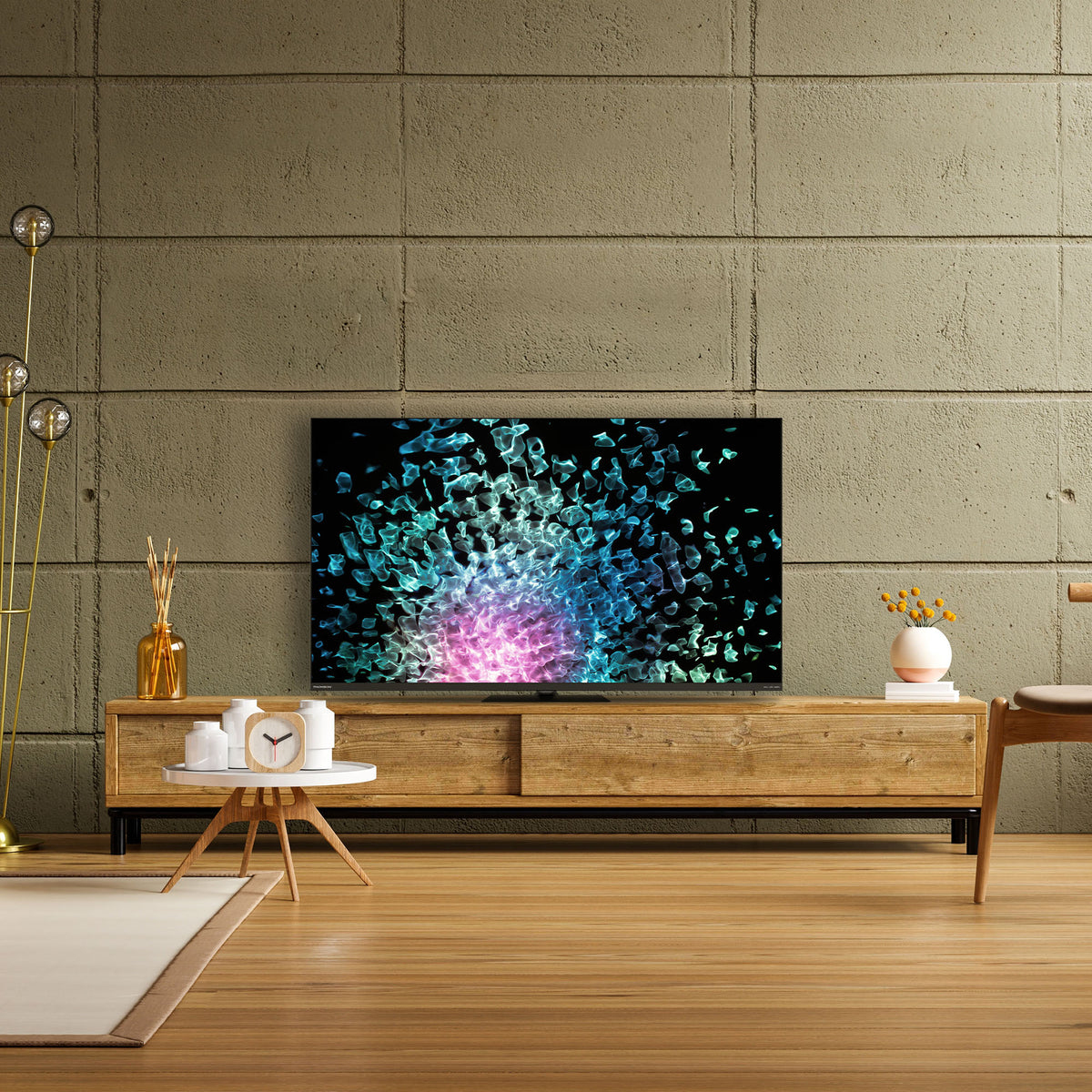 Una TV su un mobile in legno davanti a una parete in cemento, con decorazioni.