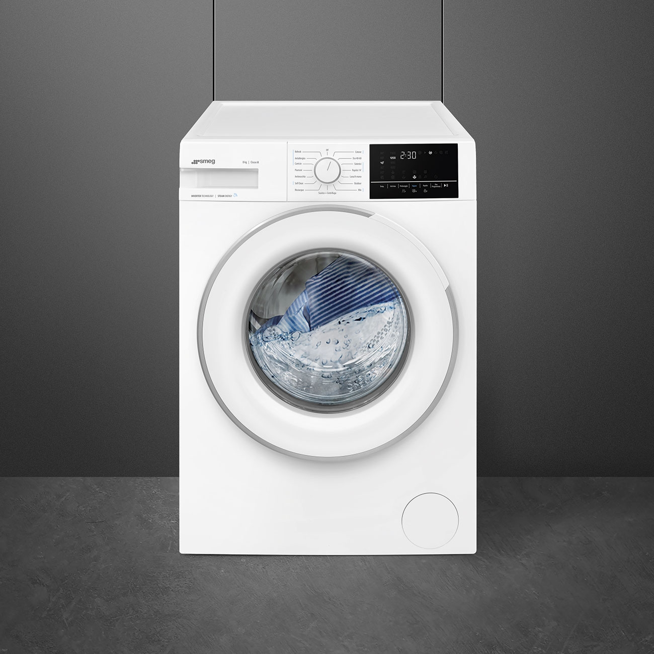 Una lavatrice bianca Smeg su sfondo grigio mostra bucato blu nel cestello.