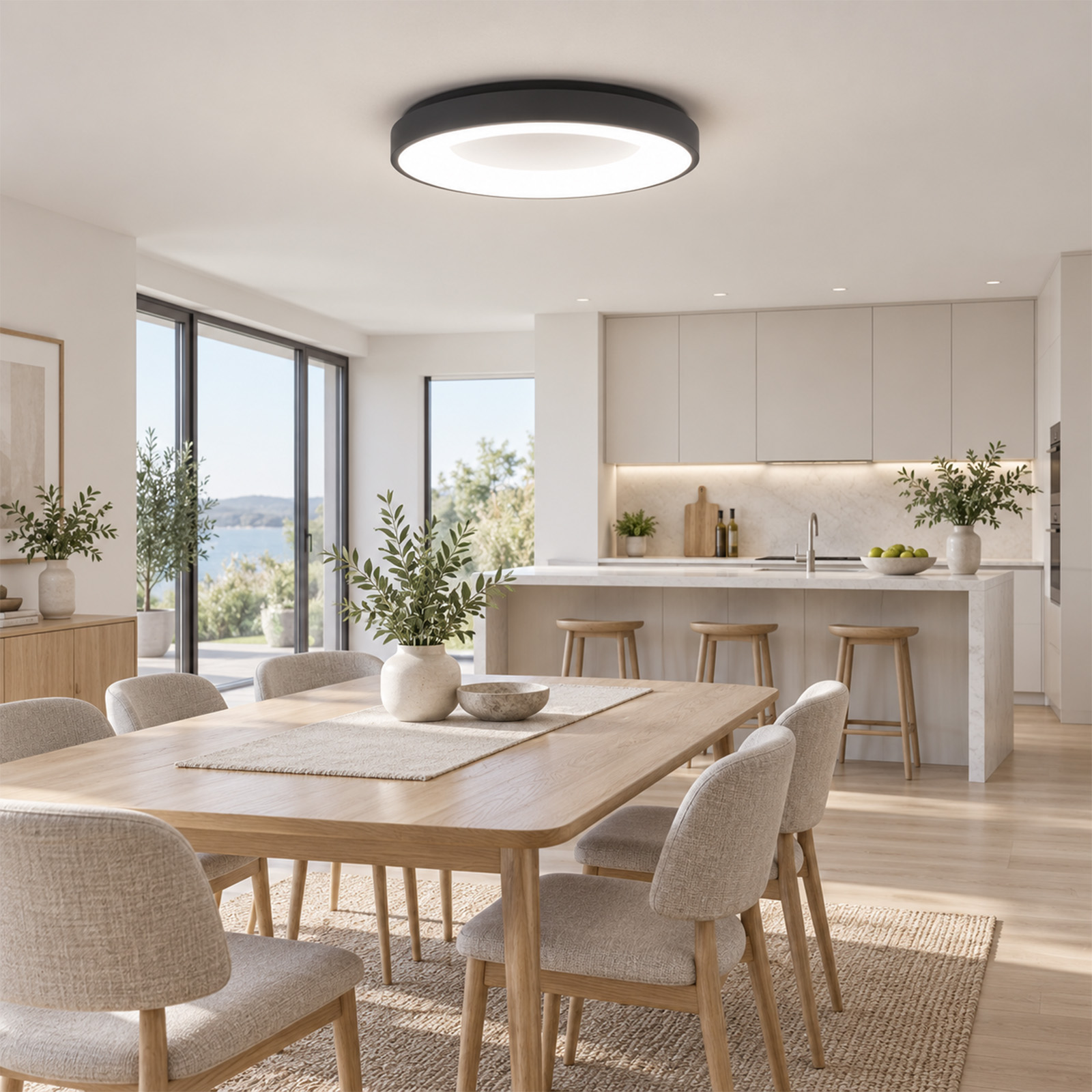 Moderna y luminosa cocina con comedor, mesa de madera, sillas, plantas y gran lámpara.