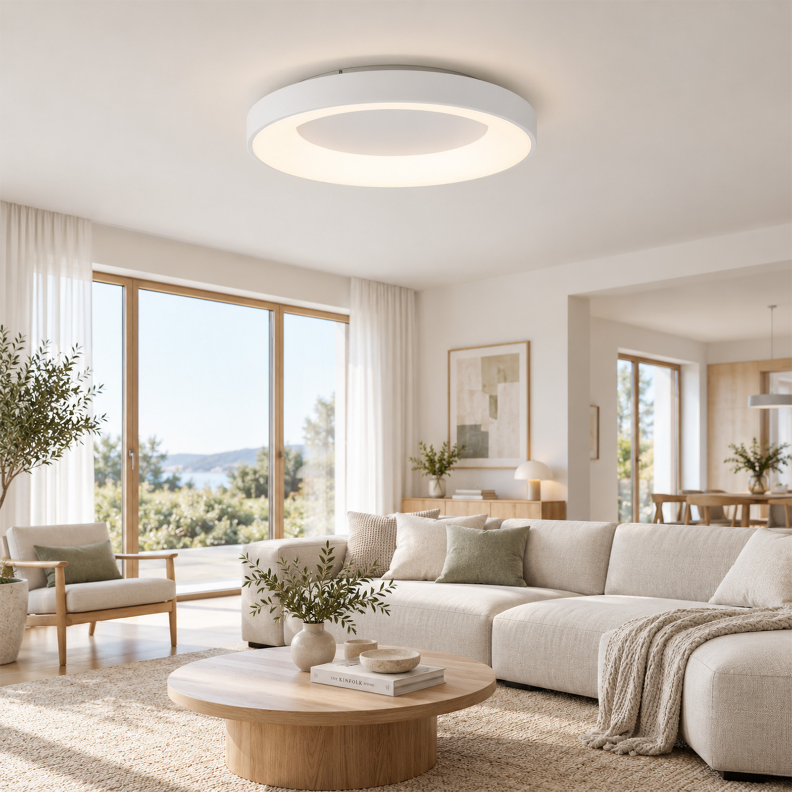 Una sala de estar moderna con una gran lámpara de techo blanca y redonda, un sofá beige y una mesa de centro.