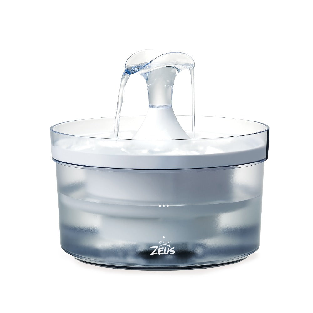 Una fuente para mascotas Zeus blanca con agua fluyendo en un recipiente transparente sobre fondo blanco.