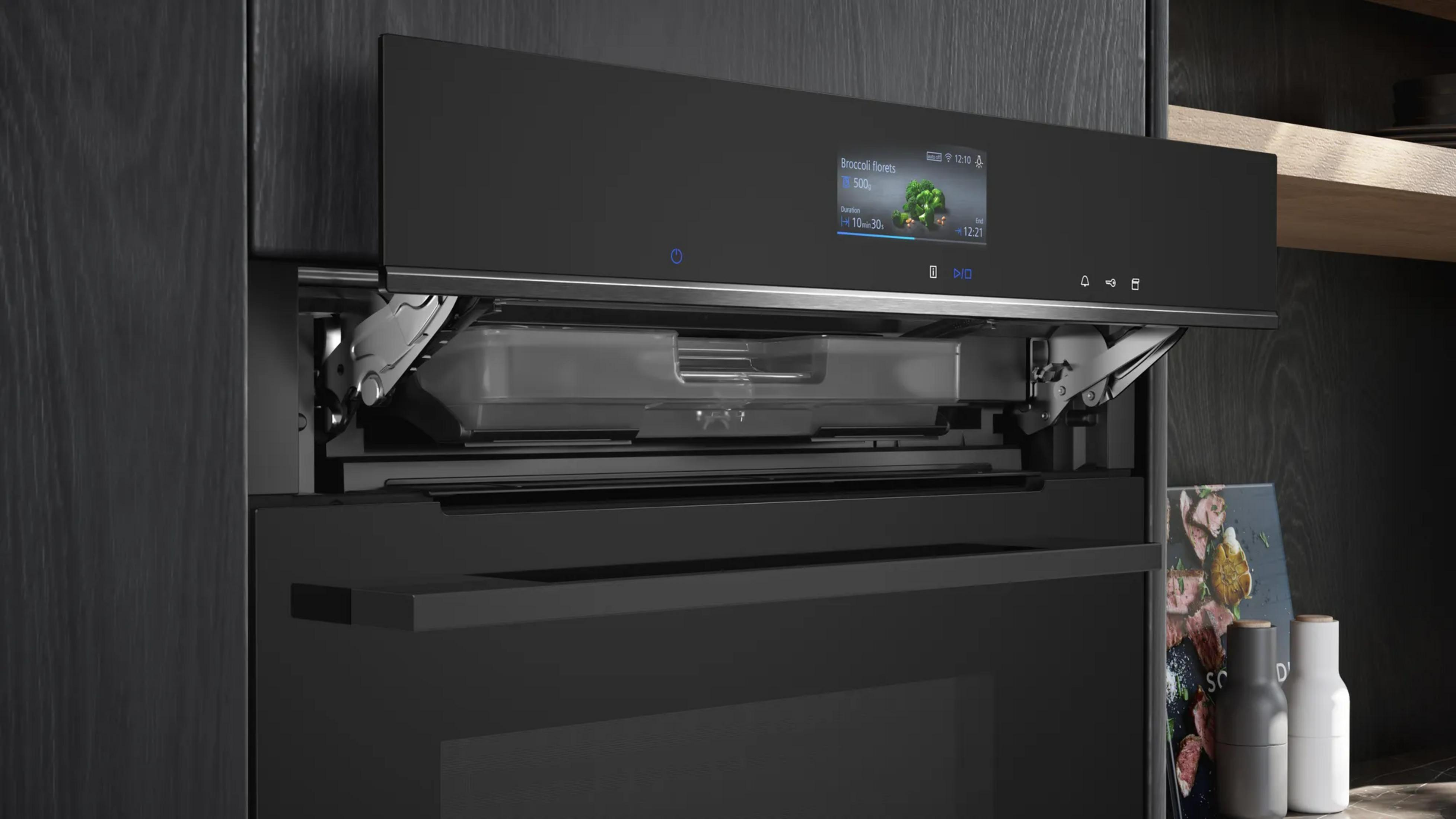 Moderne schwarze Ofenblende mit digitalem Display und geöffnetem Fach für Wassertank.