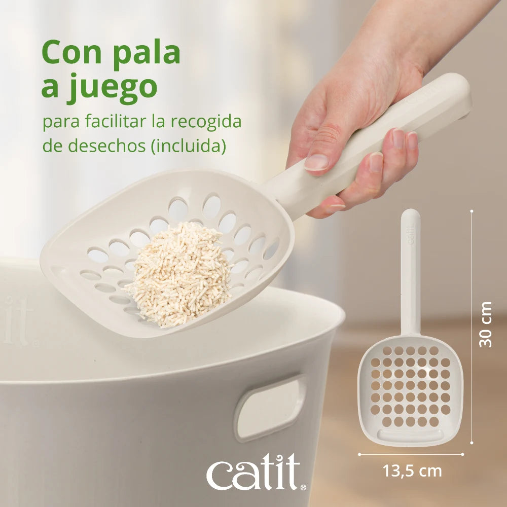 Mano sosteniendo una pala para arena de gatos beige sobre un cubo.
