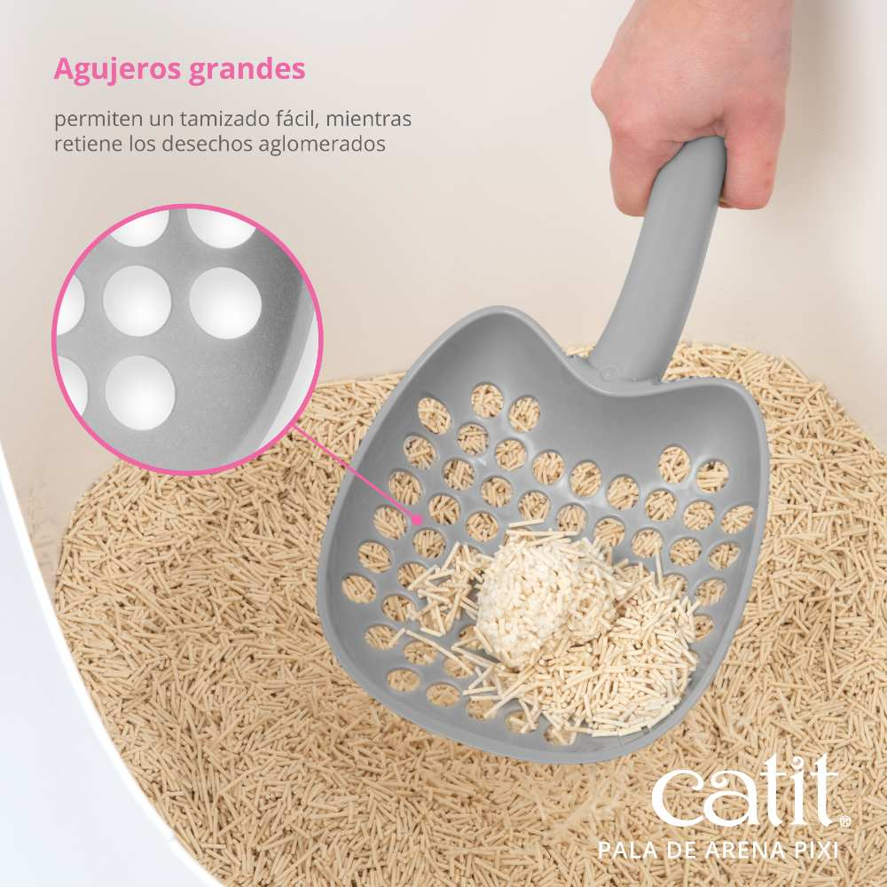 Una pala gris para arena de gatos con grandes agujeros tamiza la arena fina y retiene los grumos.