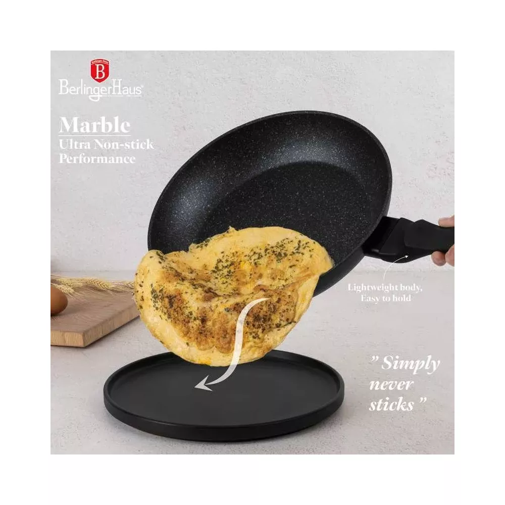 Une main tient une poêle noire antiadhésive pendant qu'une omelette glisse sur une assiette noire.