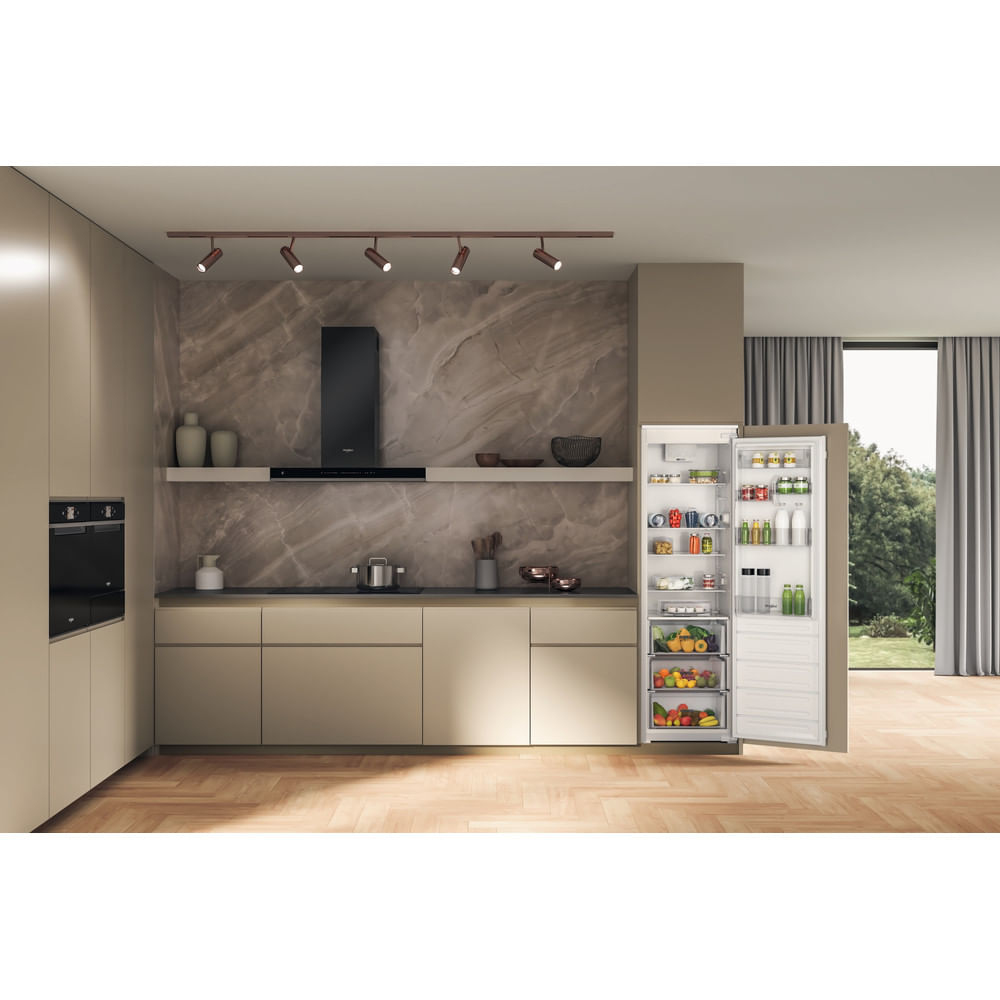 Una cucina moderna con mobili beige, paraschizzi in marmo e un frigorifero aperto pieno di cibo.