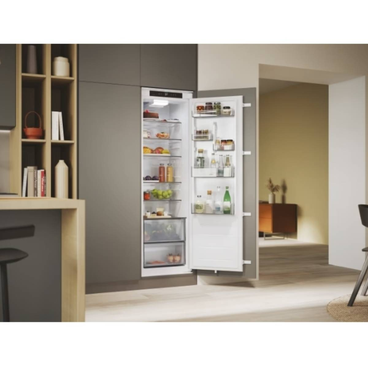 Un refrigerador empotrable blanco en una cocina moderna con la puerta abierta, lleno de comida.