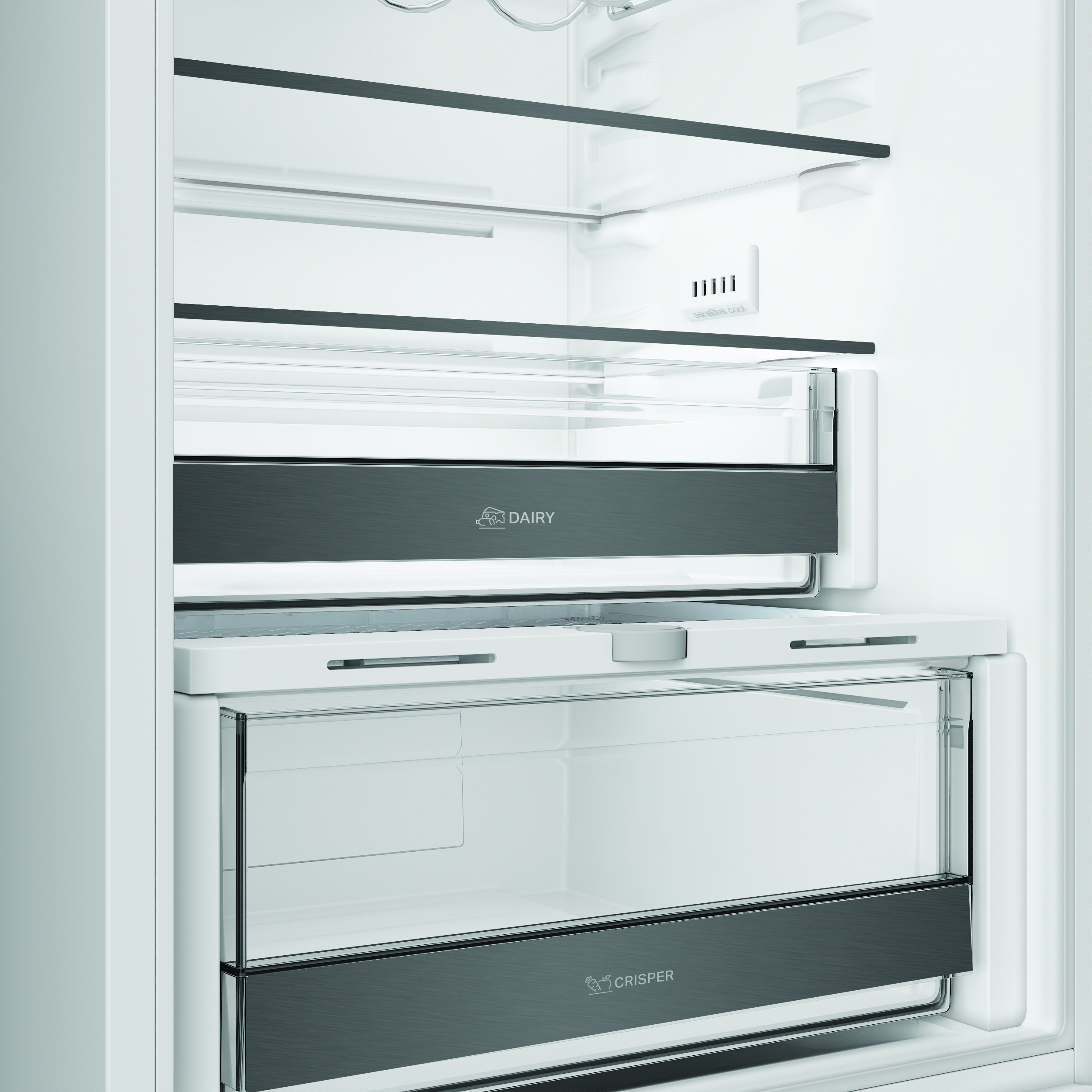 Interno di un frigorifero bianco con ripiani in vetro, scomparto latticini e cassetto verdura.