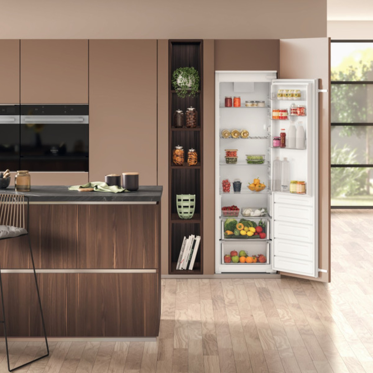Una cucina moderna con mobili marroni, un'isola scura e un frigorifero bianco aperto.