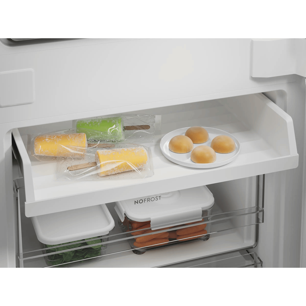 Un congelatore bianco con cassetti contenenti ghiaccioli, panini e verdure.