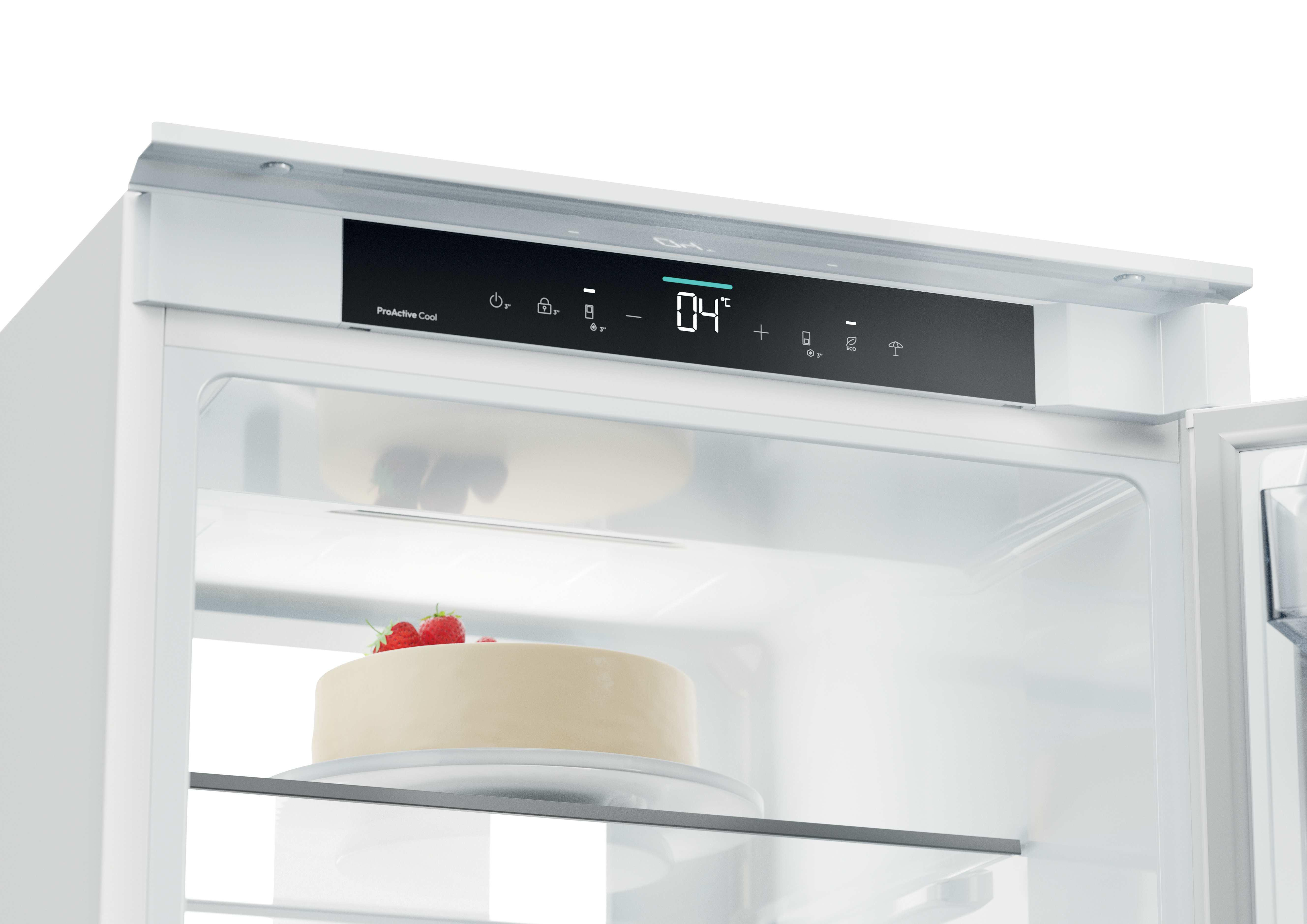 Un frigorifero aperto con display digitale a 04 gradi e una torta con fragole su un ripiano.