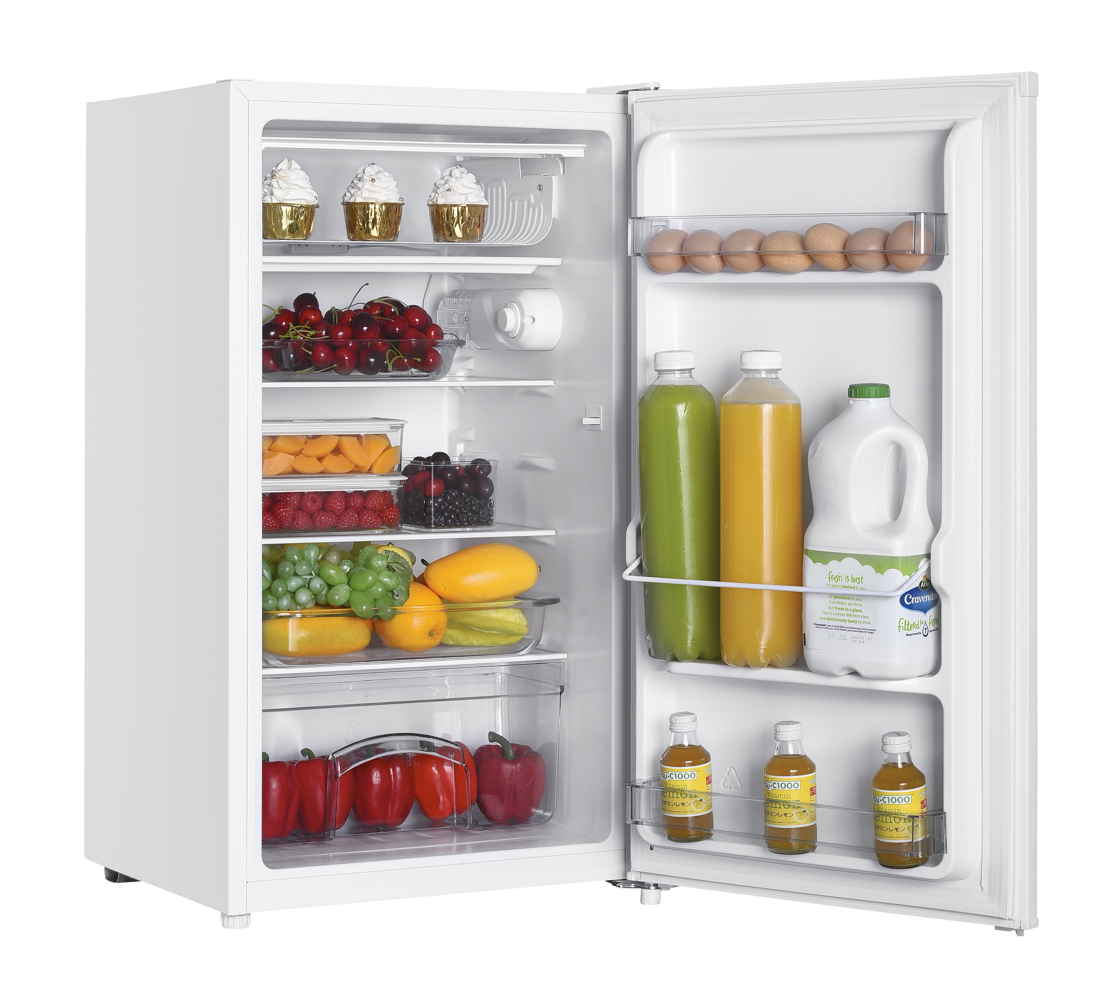 Un frigorifero bianco aperto pieno di cupcake, ciliegie, bacche, frutta, bottiglie di succo e latte.