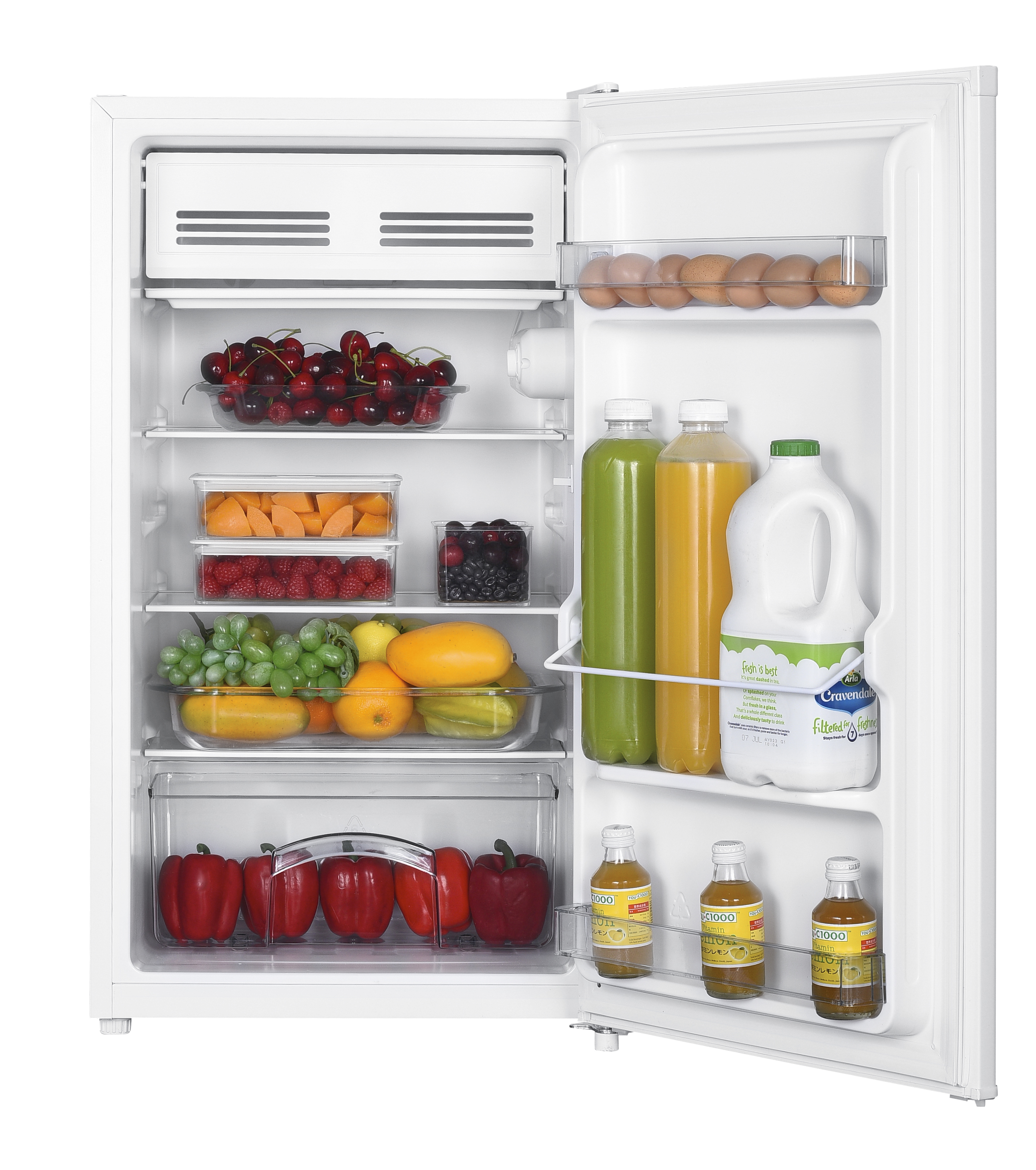 Un frigorifero bianco aperto pieno di frutta fresca, verdura, uova, latte, succo e piccole bottiglie.