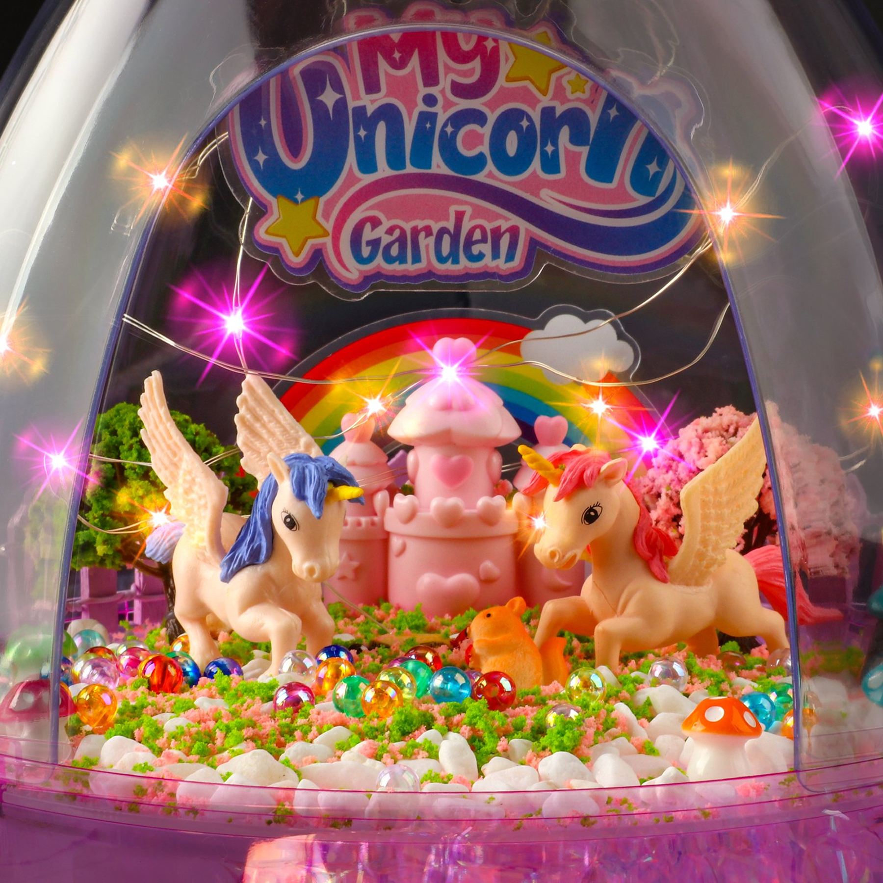 Szklana kopuła z My Unicorn Garden, dwoma skrzydlatymi jednorożcami, zamkiem, koralikami i lampkami.