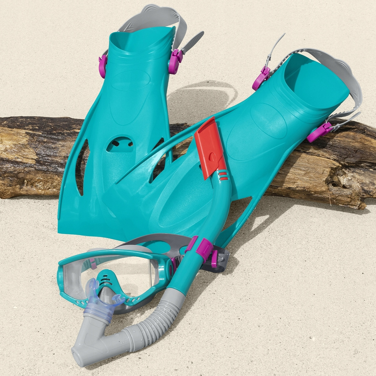 Turkusowy sprzęt do snorkeling z płetwami i maską na drewnianym klocu.