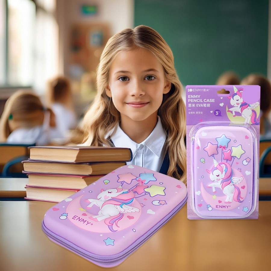 Uśmiechnięta blond dziewczynka siedzi w ławce z ułożonymi książkami i piórnikiem z jednorożcem.