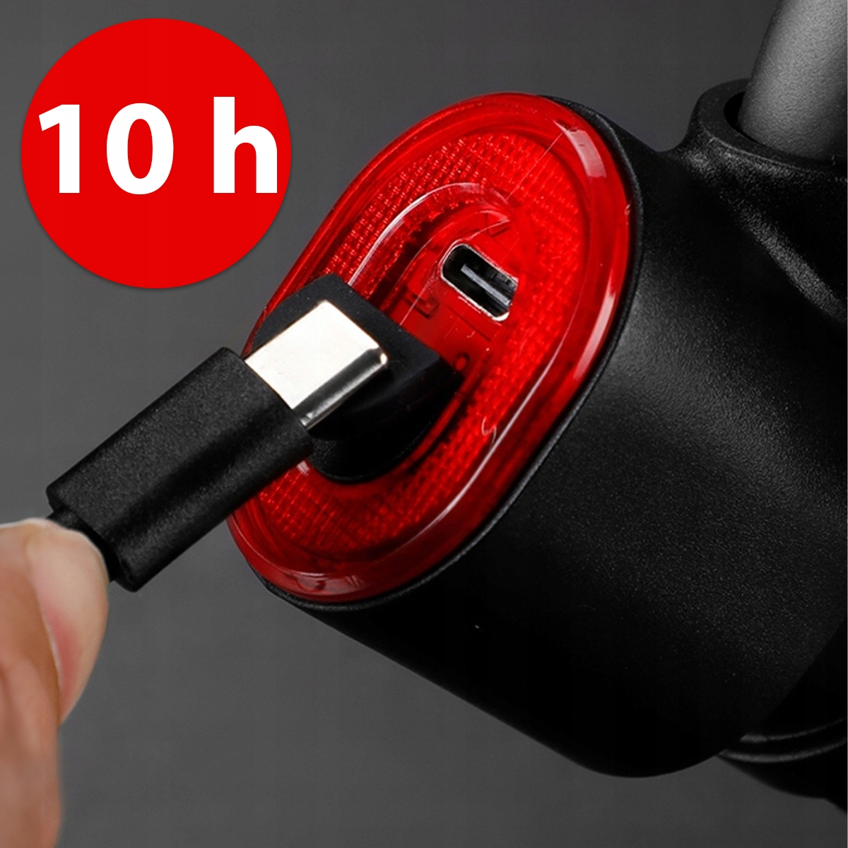Kabel USB-C jest podłączany do portu ładowania czerwono-czarnej lampki rowerowej tylnej.