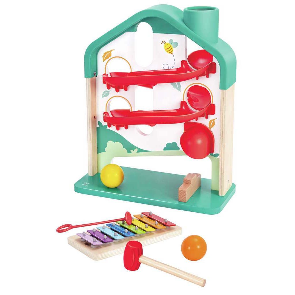 Ein Holzspielzeug-Haus mit roten Bahnen, Bällen, einem Xylophon und einem roten Hammer.