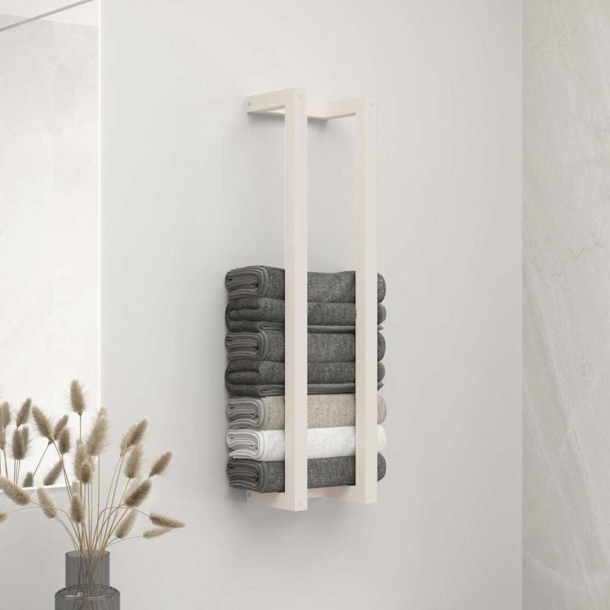 Ein weißer Handtuchhalter hängt an der Wand und hält gefaltete graue und weiße Handtücher.