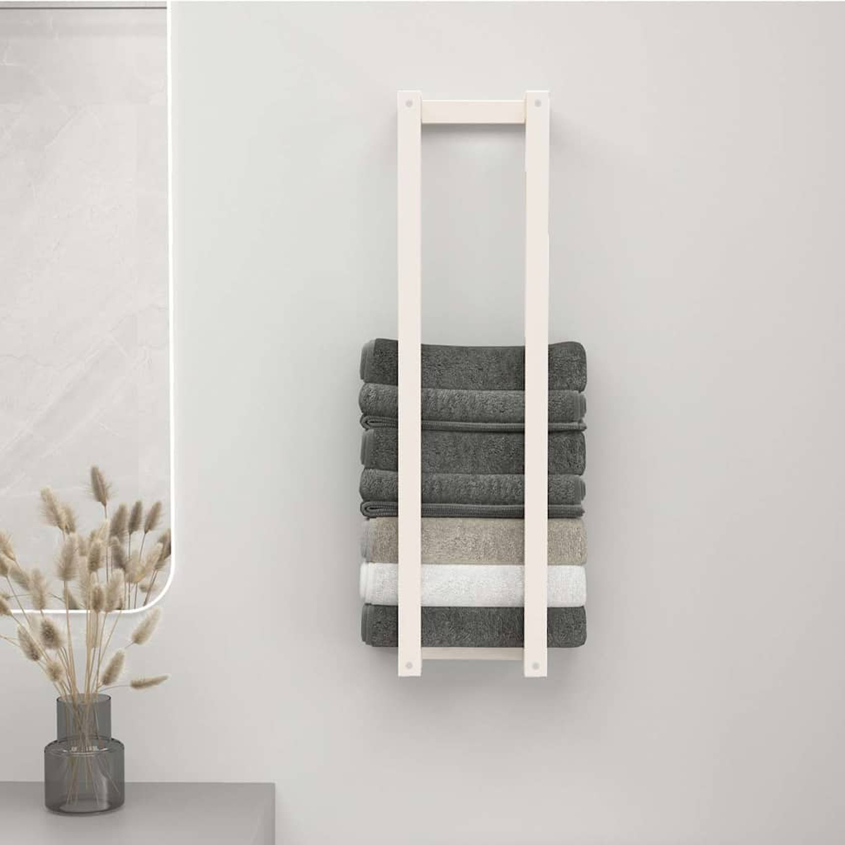 Ein weißer Handtuchhalter an einer hellen Wand hält gefaltete graue, beige und weiße Handtücher.